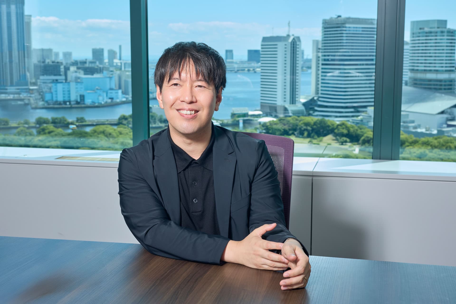 a man in a suit is sitting at a table in front of a window .