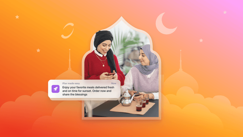 Two women in hijabs seated with tea, one looking at her phone displaying an "Iftar made easy" notification, against a festive Ramadan-themed background.