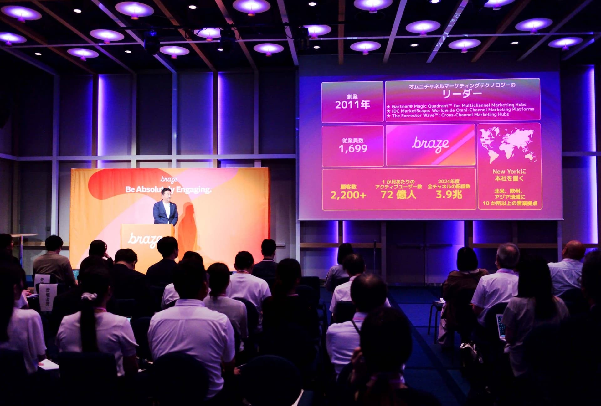 a group of people are sitting in front of a large screen in a conference room .