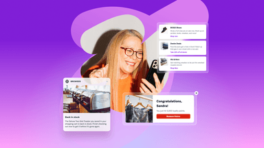 a woman wearing glasses is smiling while looking at her phone