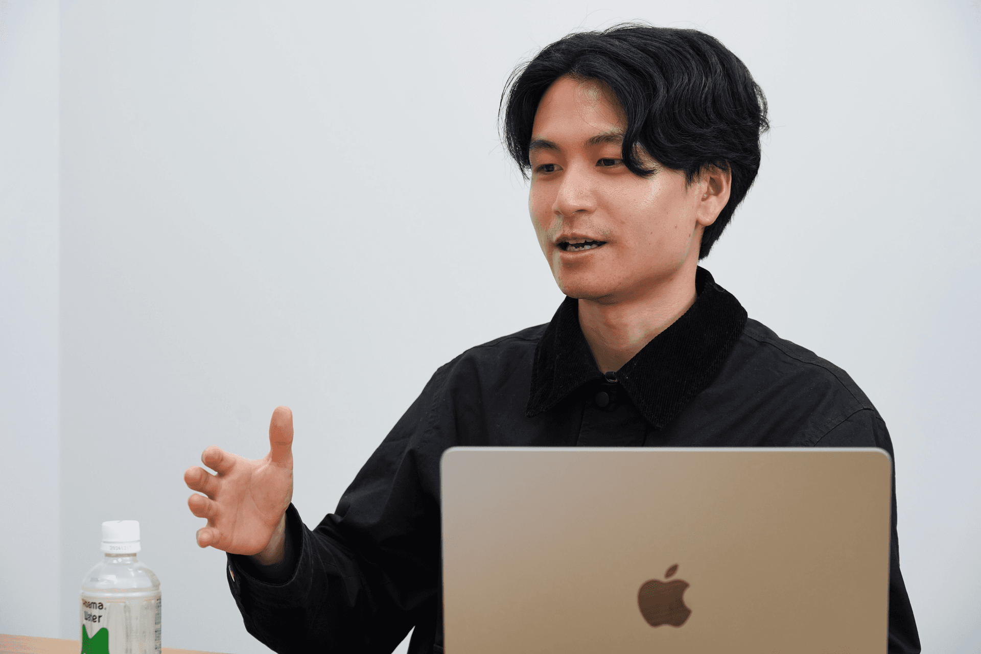 a man sitting in front of an apple laptop