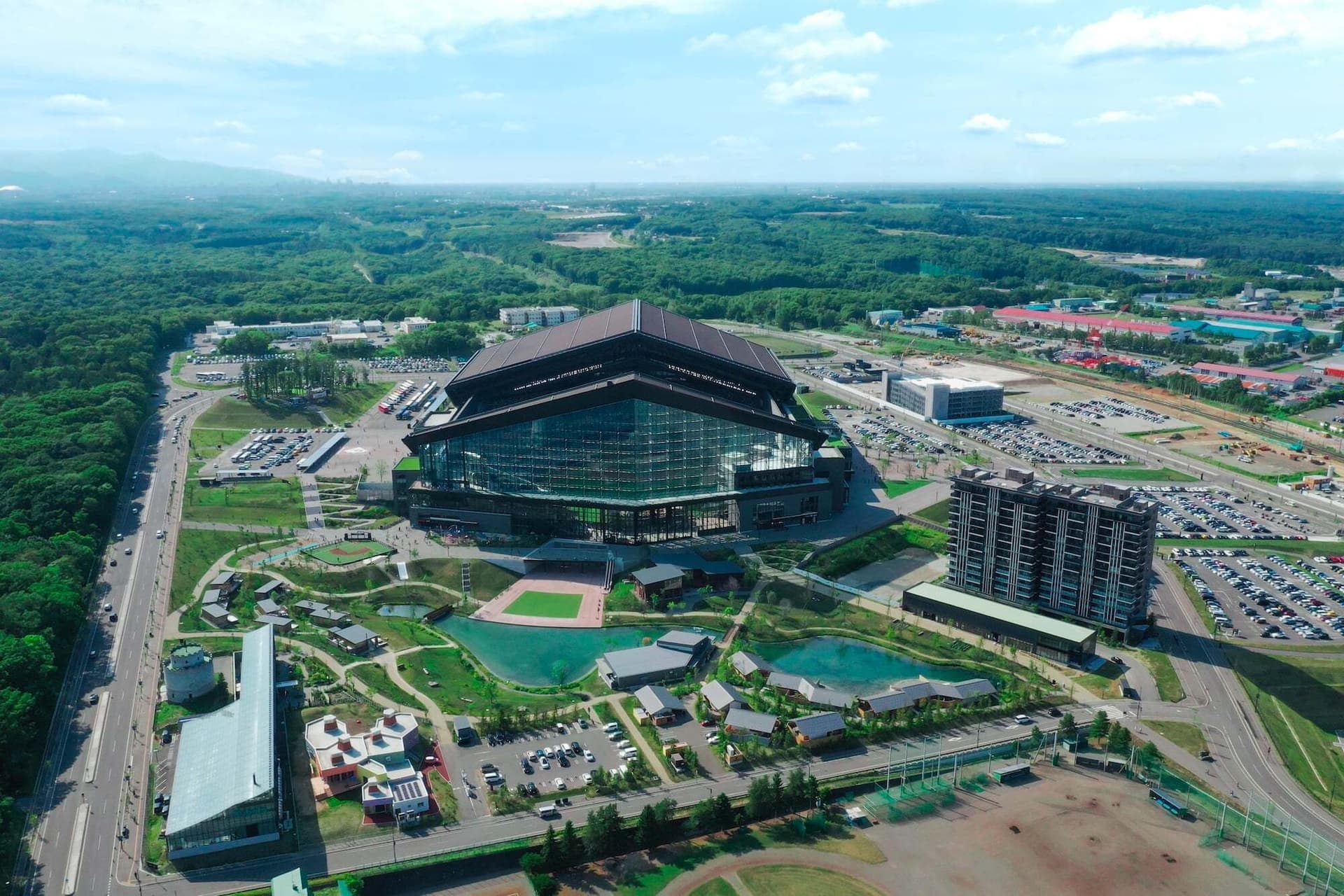 an aerial view of a baseball stadium in a city surrounded by trees and buildings .