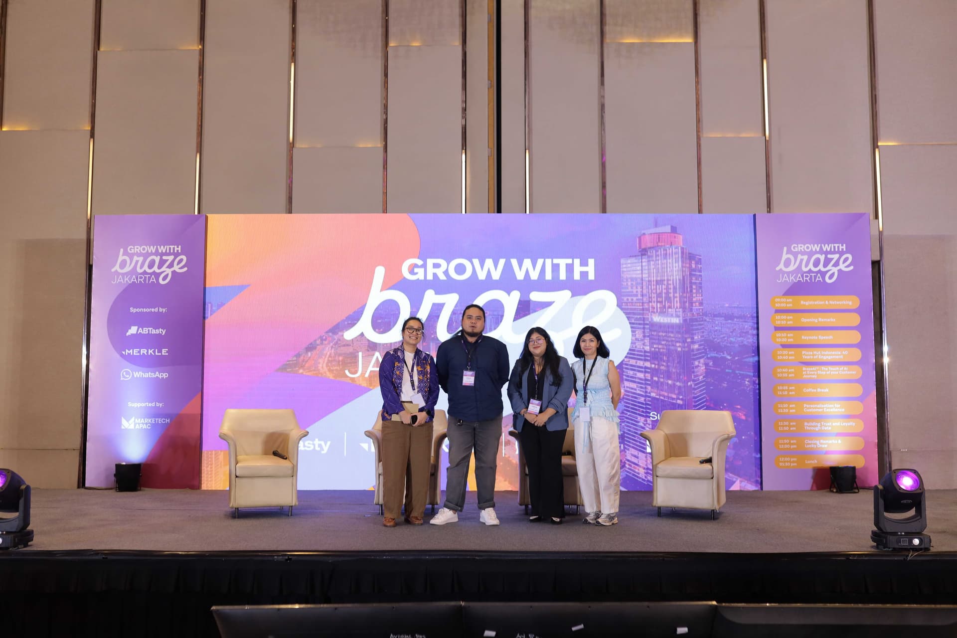 a group of people are standing in front of a stage at a conference .