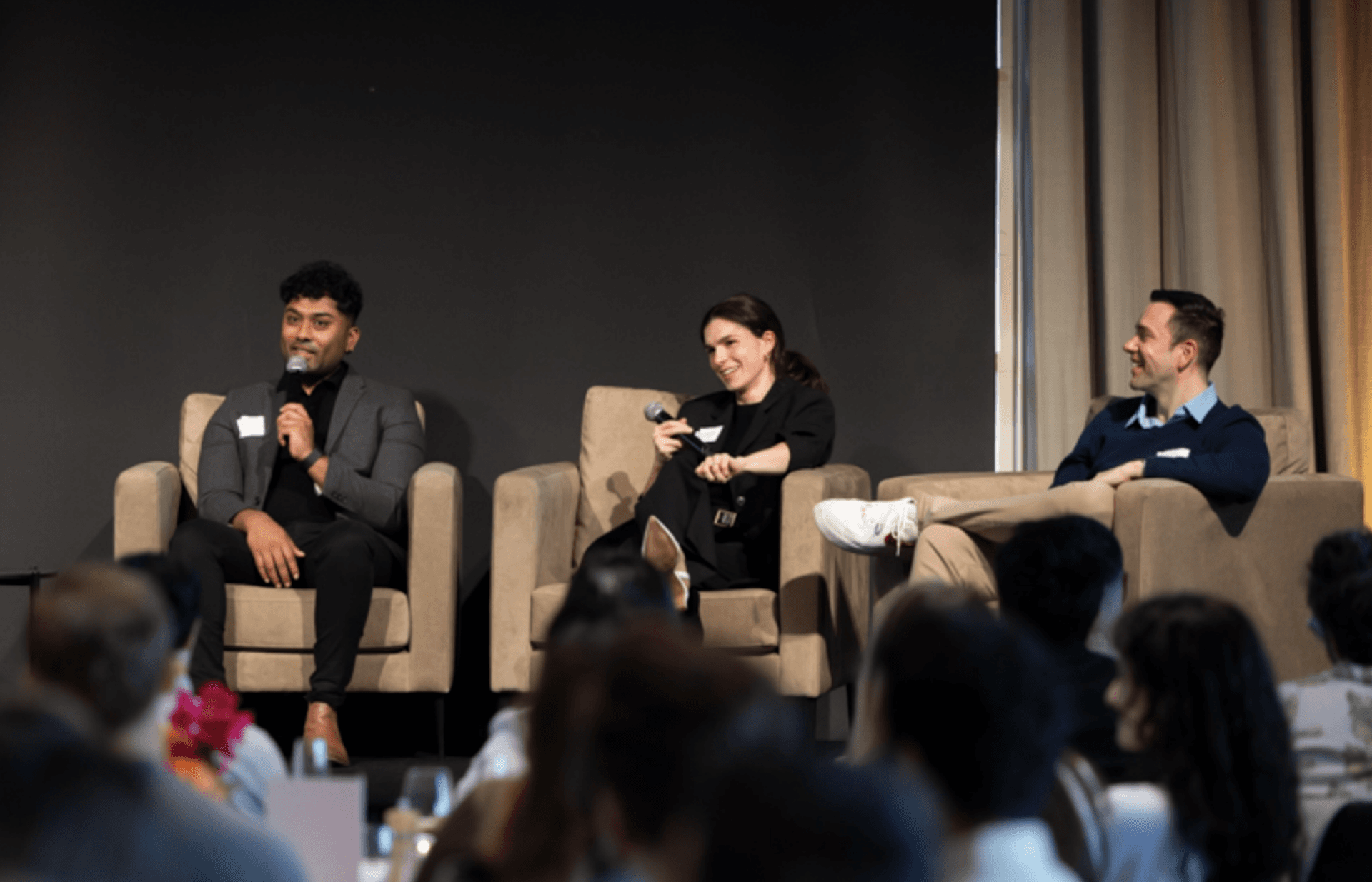 A panel of three people on stage