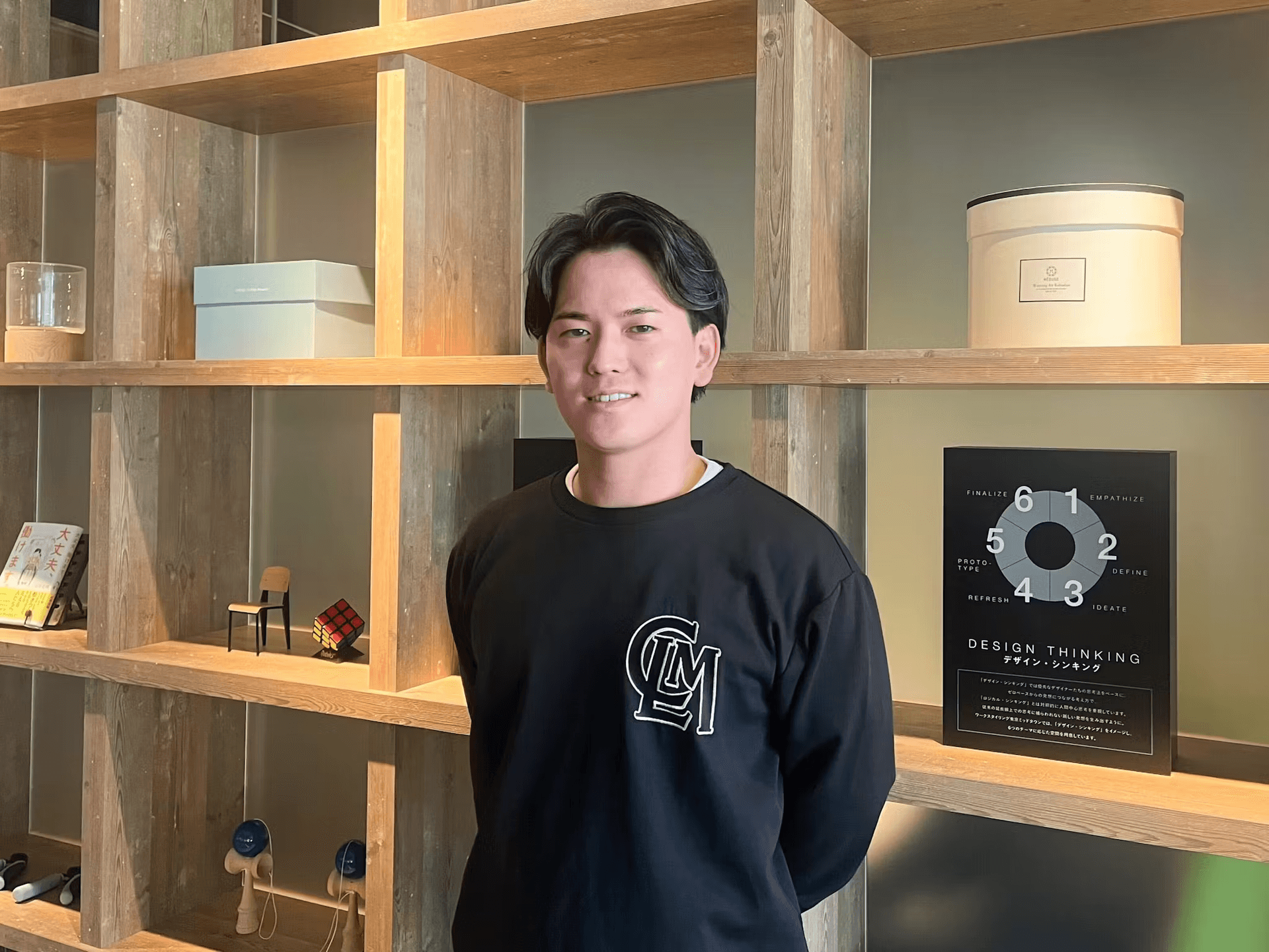 a man stands in front of a book titled design thinking