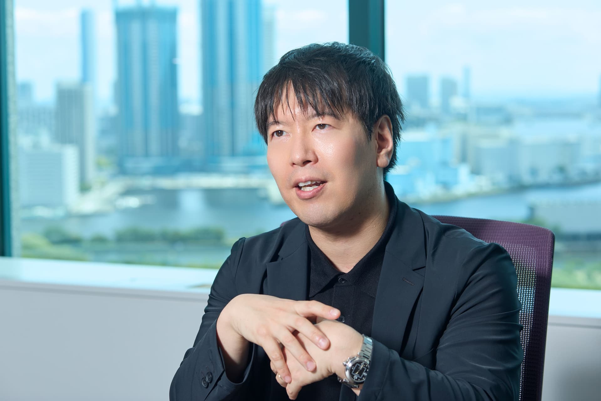 a man in a suit is sitting in a chair in front of a window .