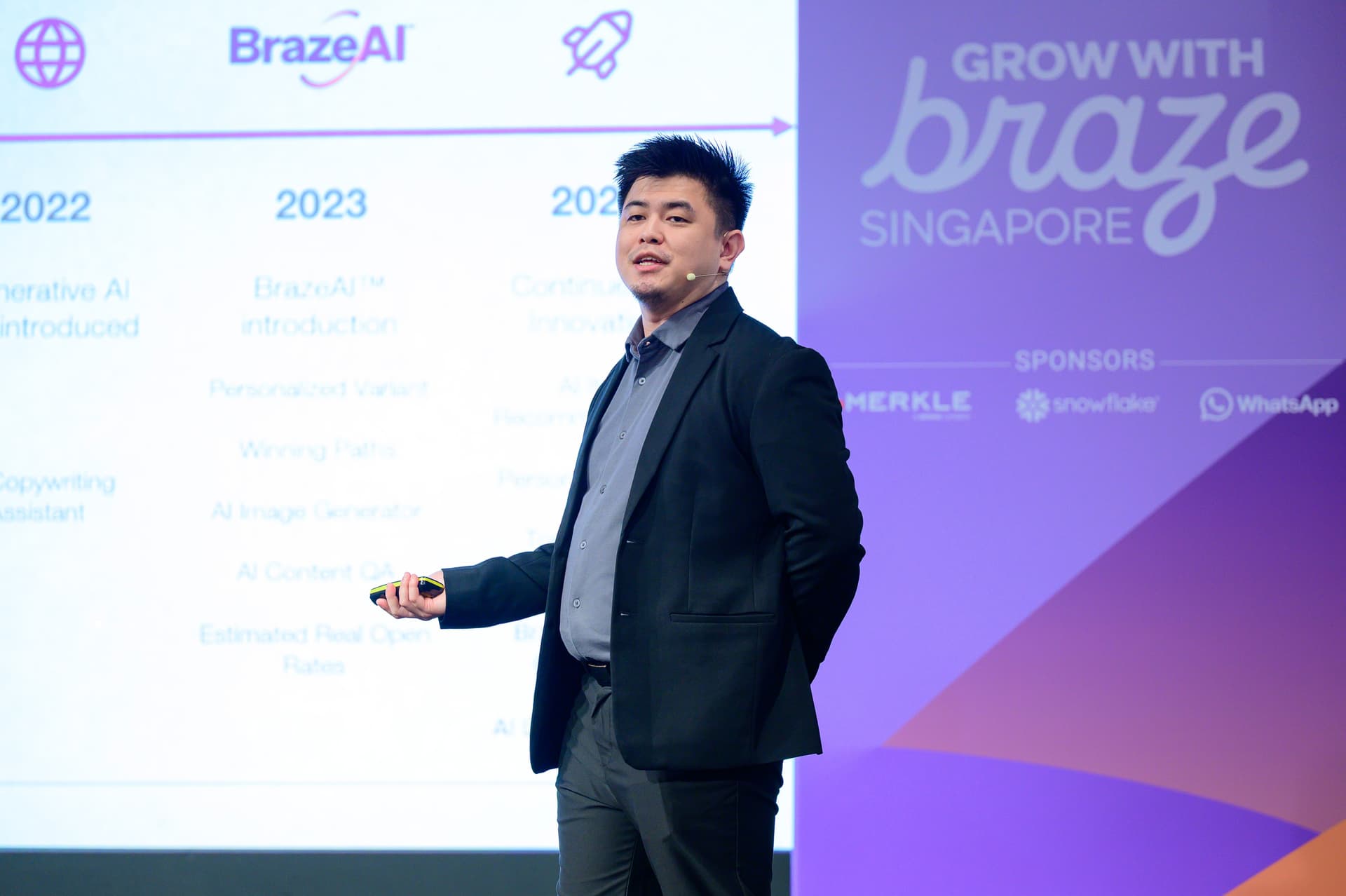 a man in a suit is giving a presentation in front of a large screen .