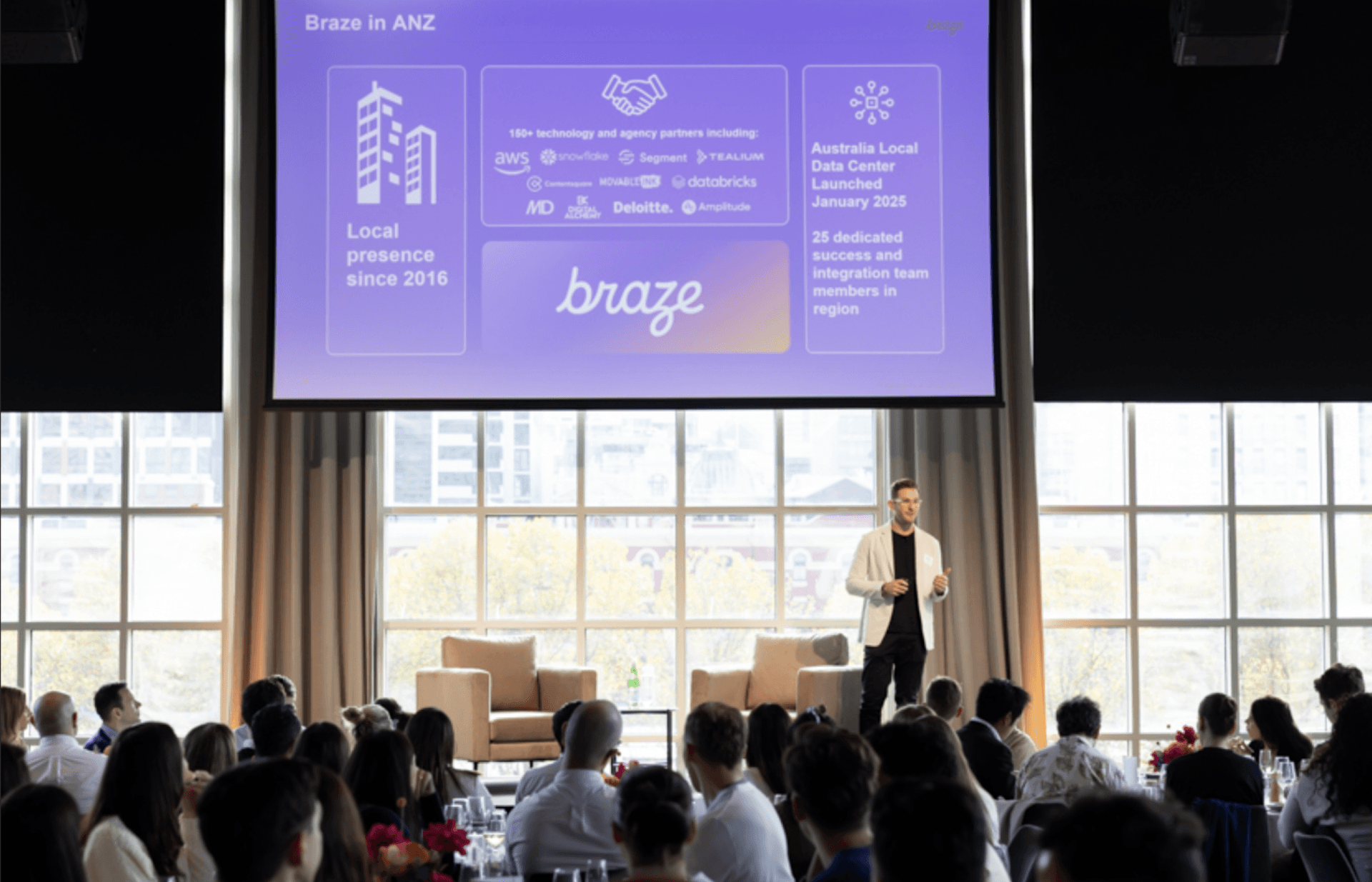 a man stands in front of a screen that says braze in anz