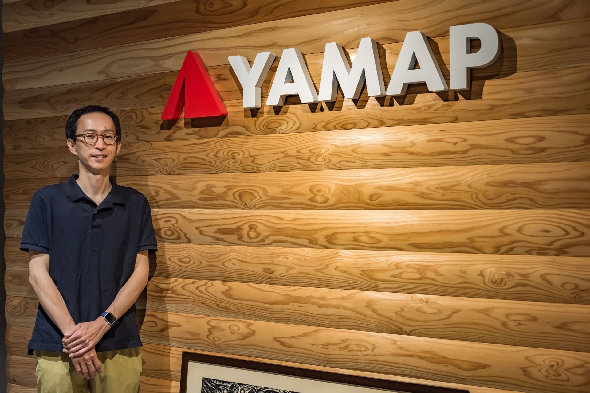 a man is standing in front of a wooden wall .
