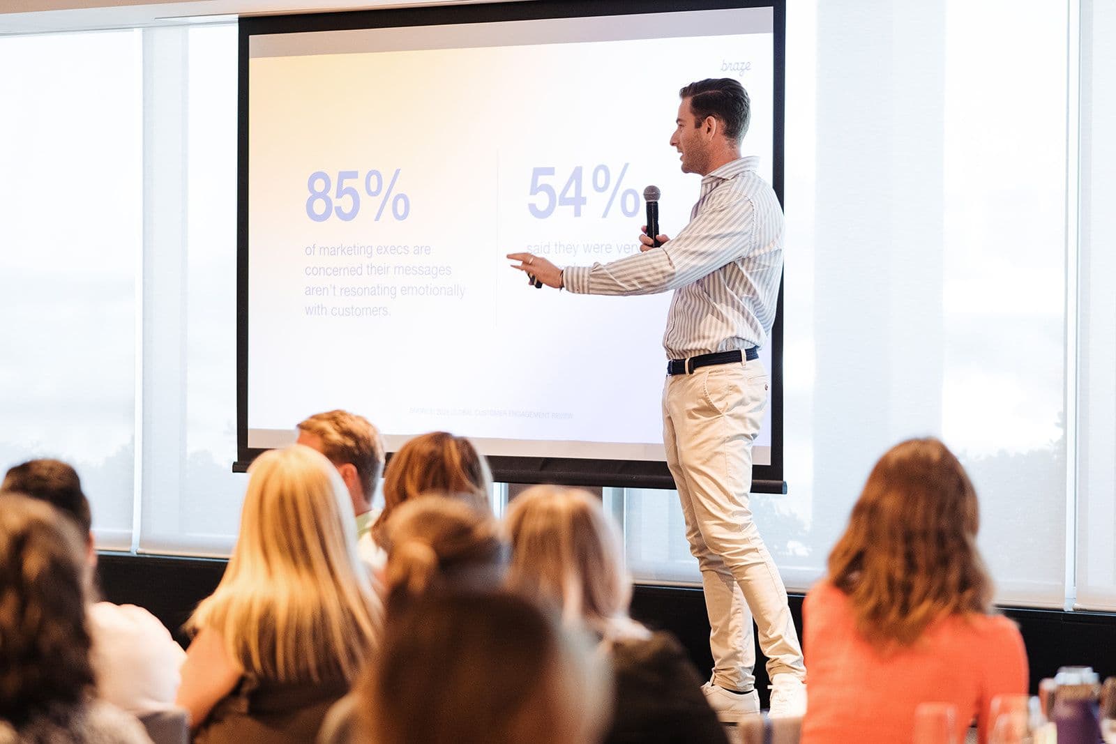 a man is giving a presentation to a group of people in front of a projector screen .
