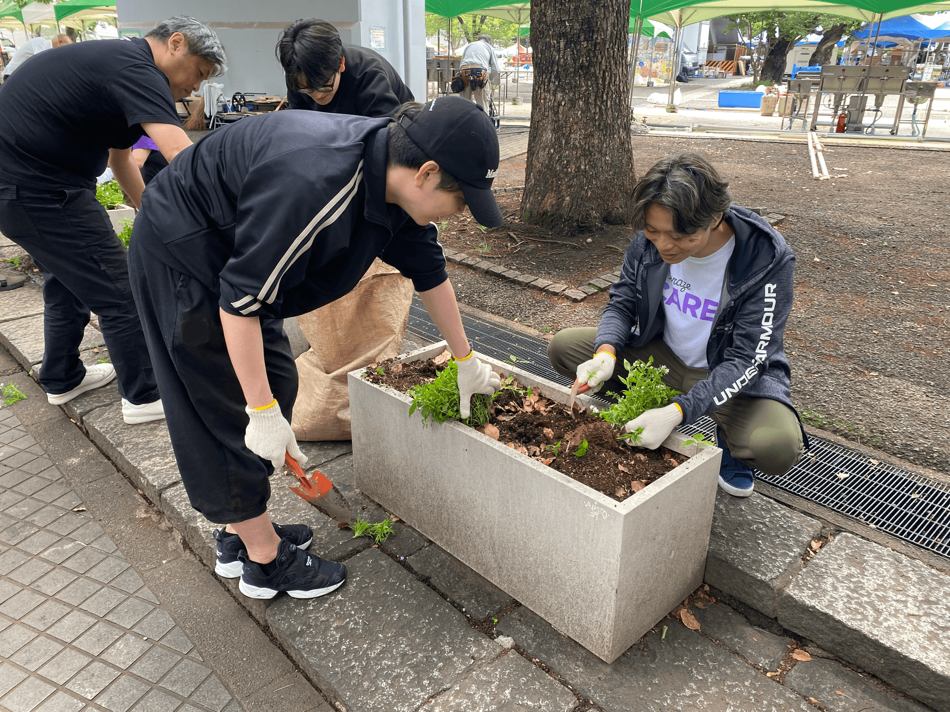 a man wearing an under armour shirt is working on a planter