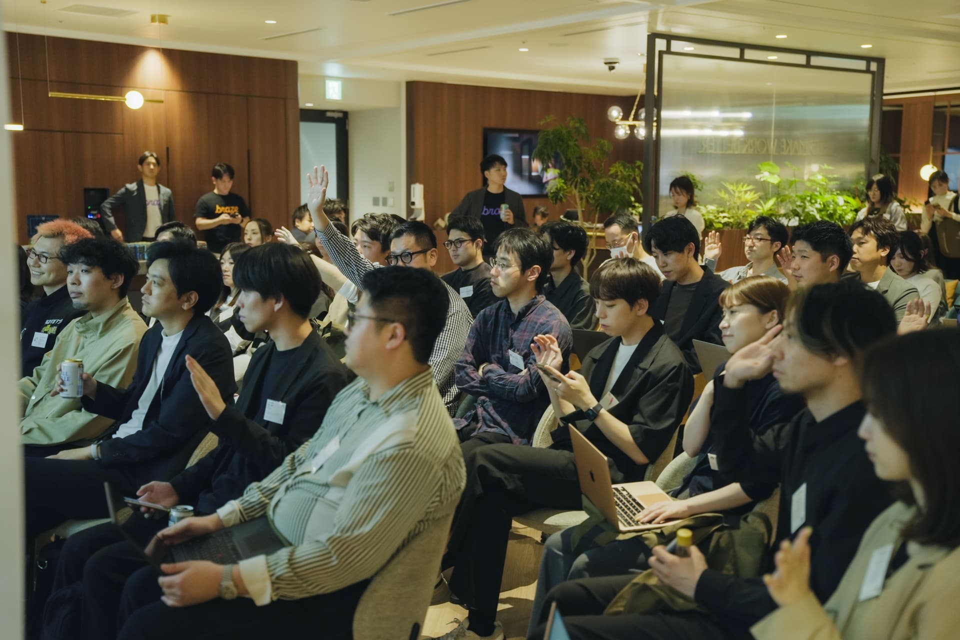 a large group of people are sitting in a room watching a presentation .