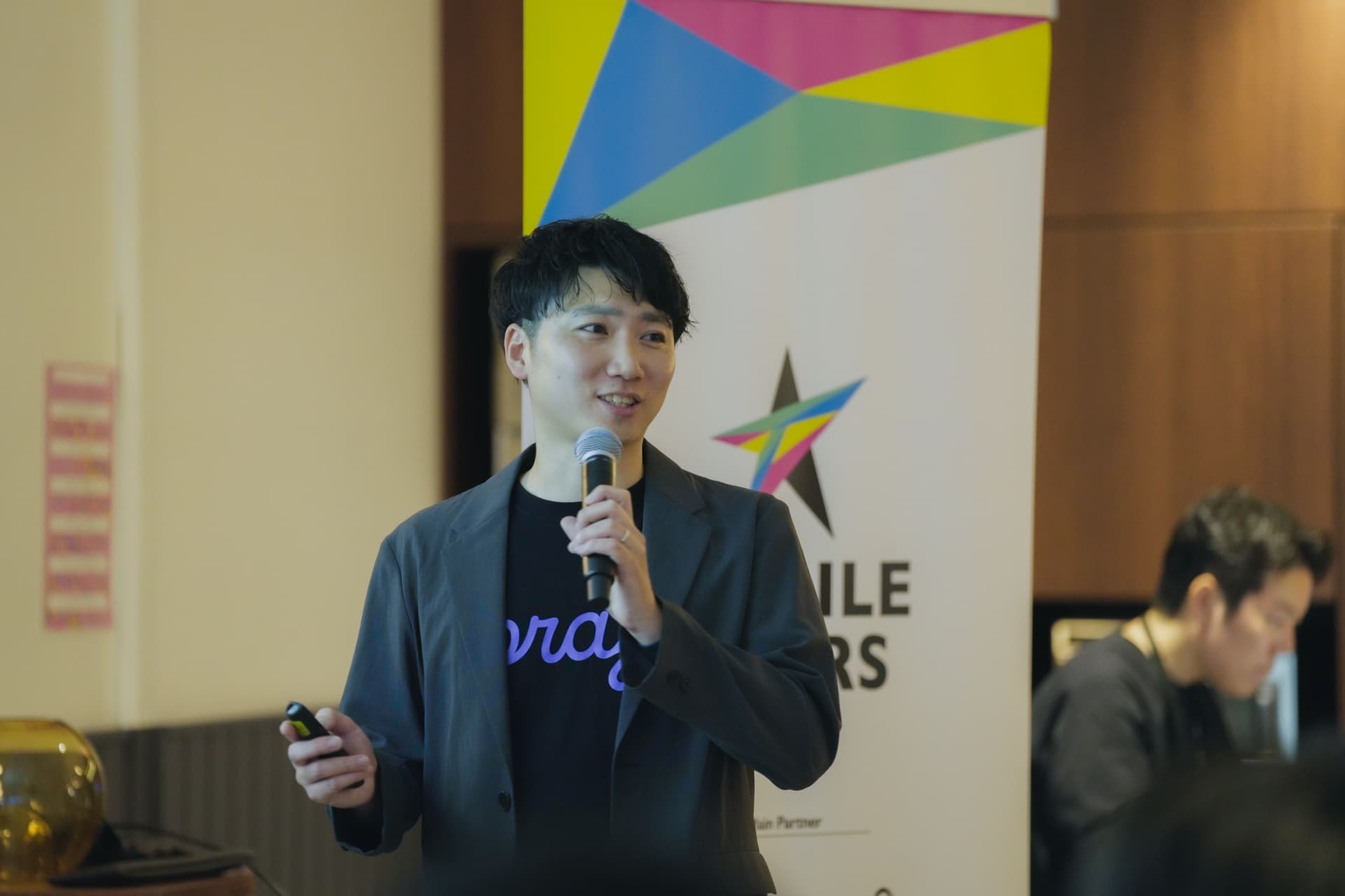 a man is standing in front of a microphone giving a presentation .