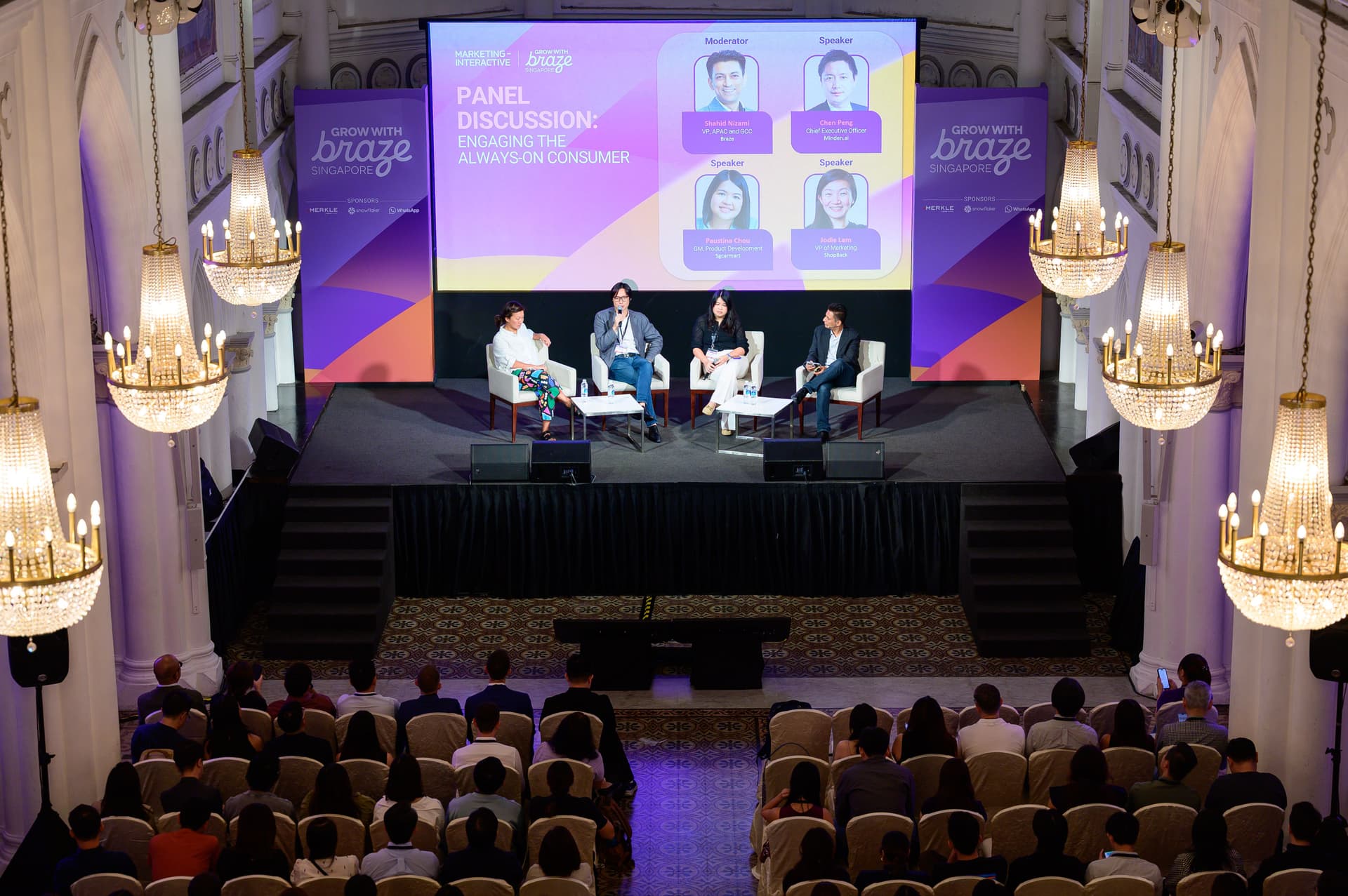 a group of people are sitting in a auditorium watching a panel discussion .