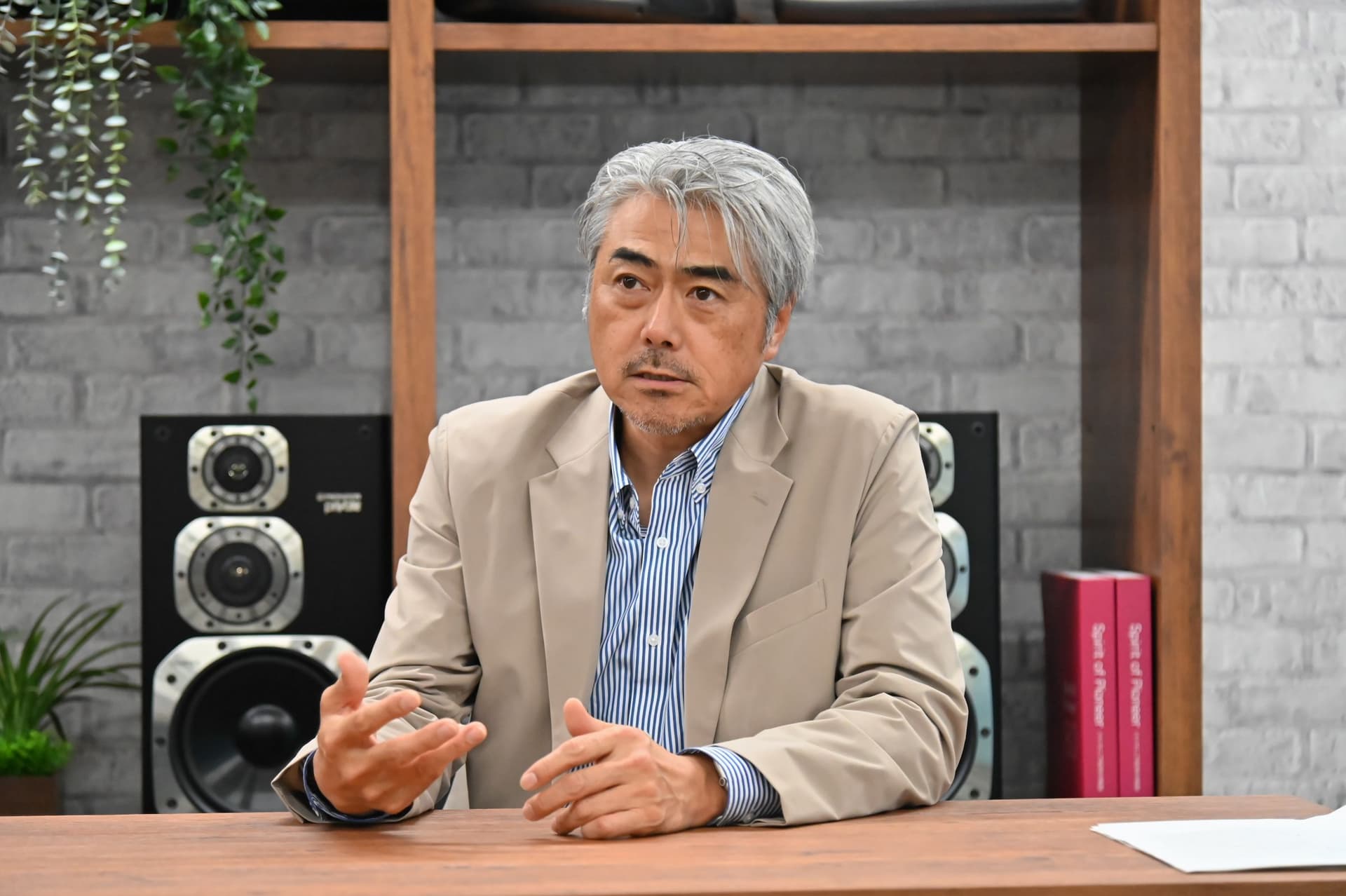 a man in a suit is sitting at a table talking to someone .