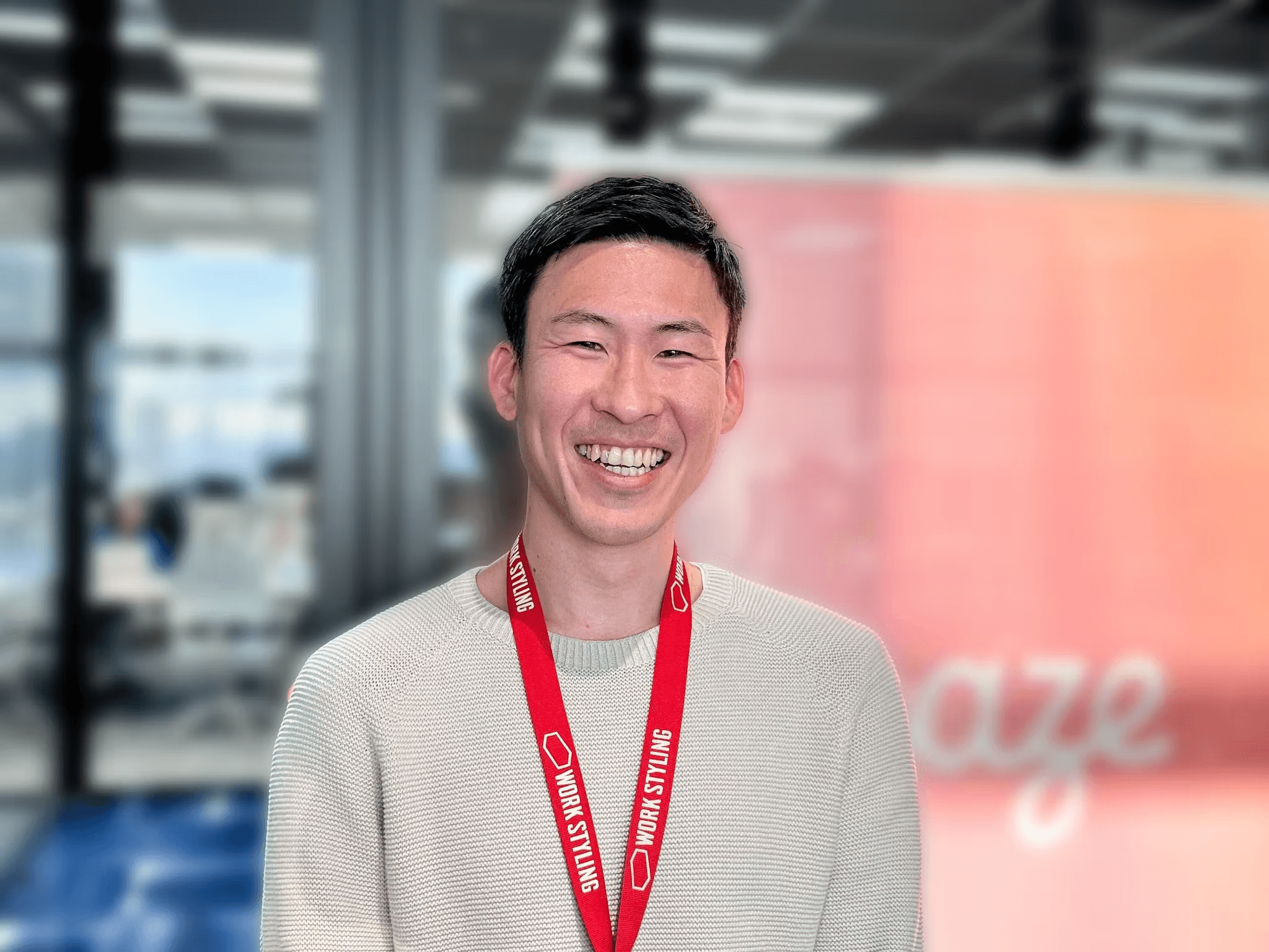 a man wearing a work styling lanyard smiles for the camera