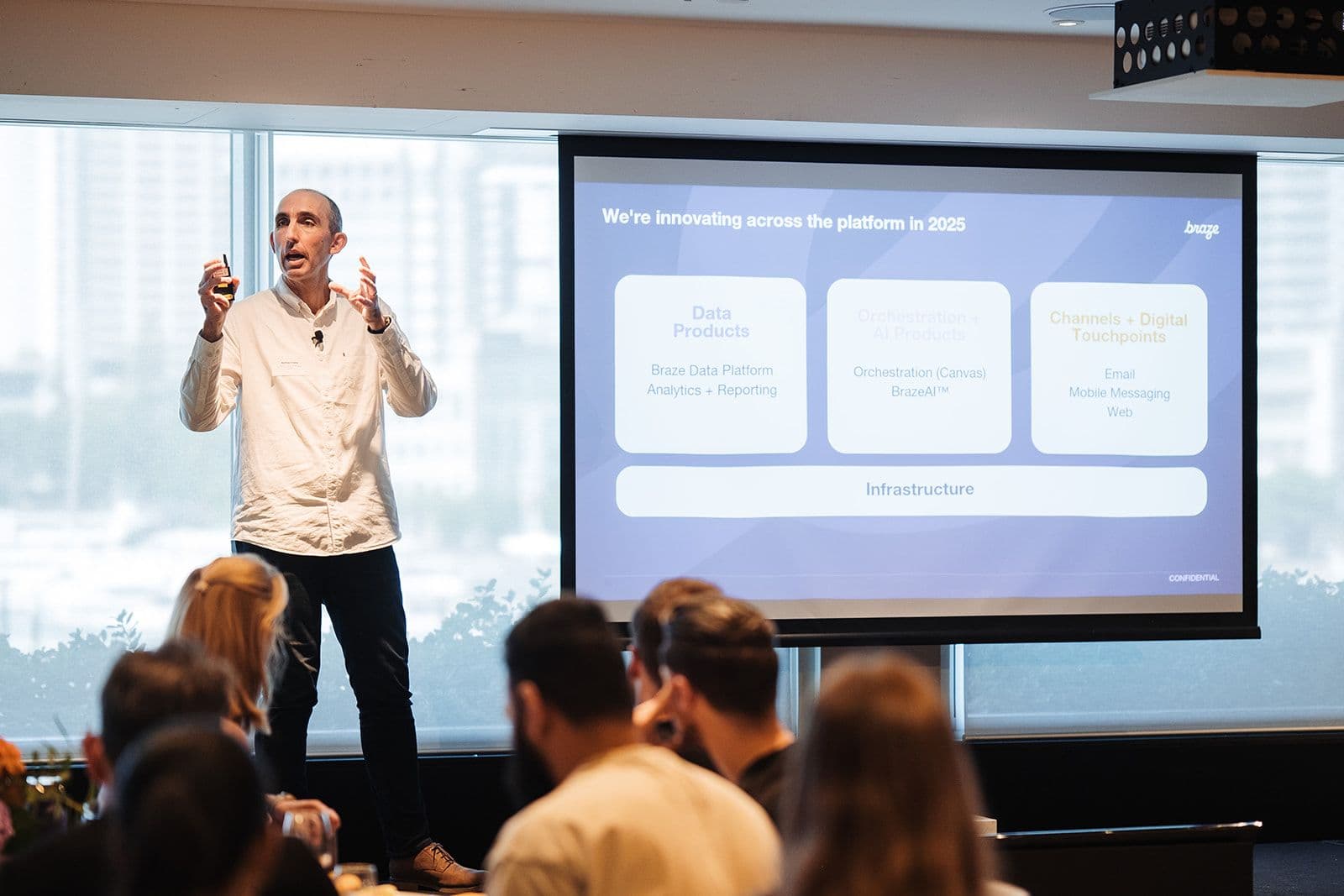 a man is giving a presentation to a group of people in front of a large screen .