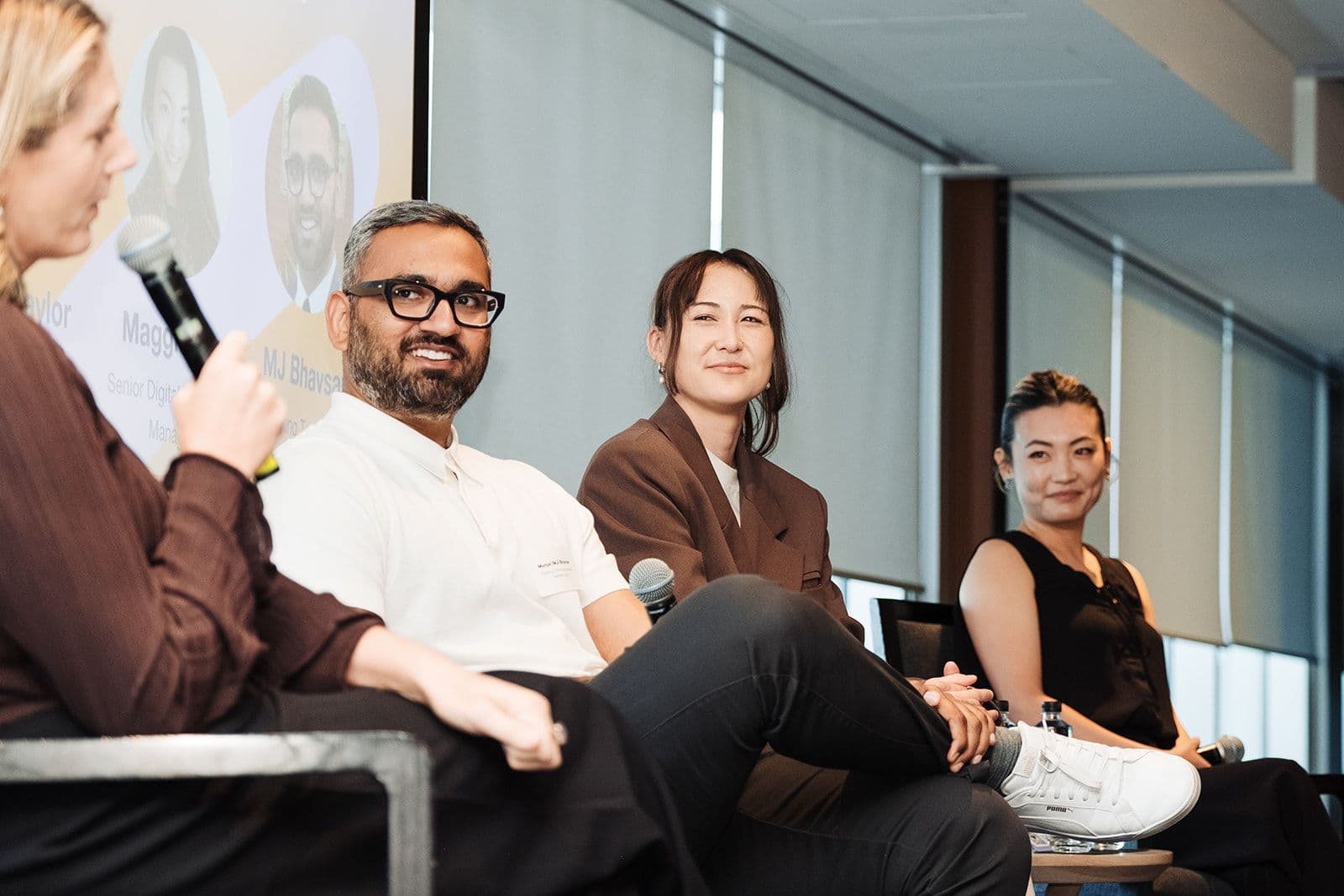 a group of people are sitting on a stage talking to each other .