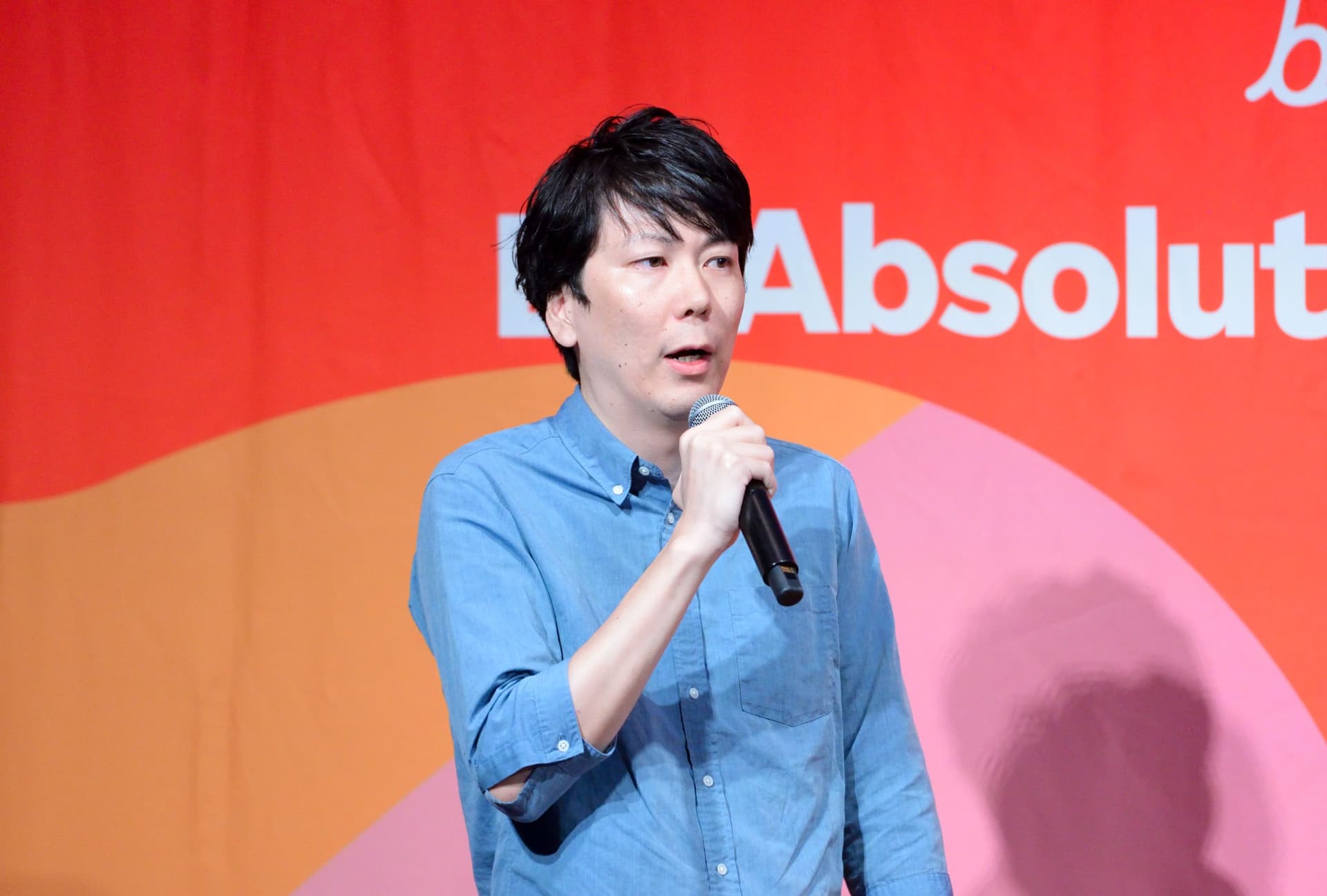 a man is holding a microphone in front of a red background .