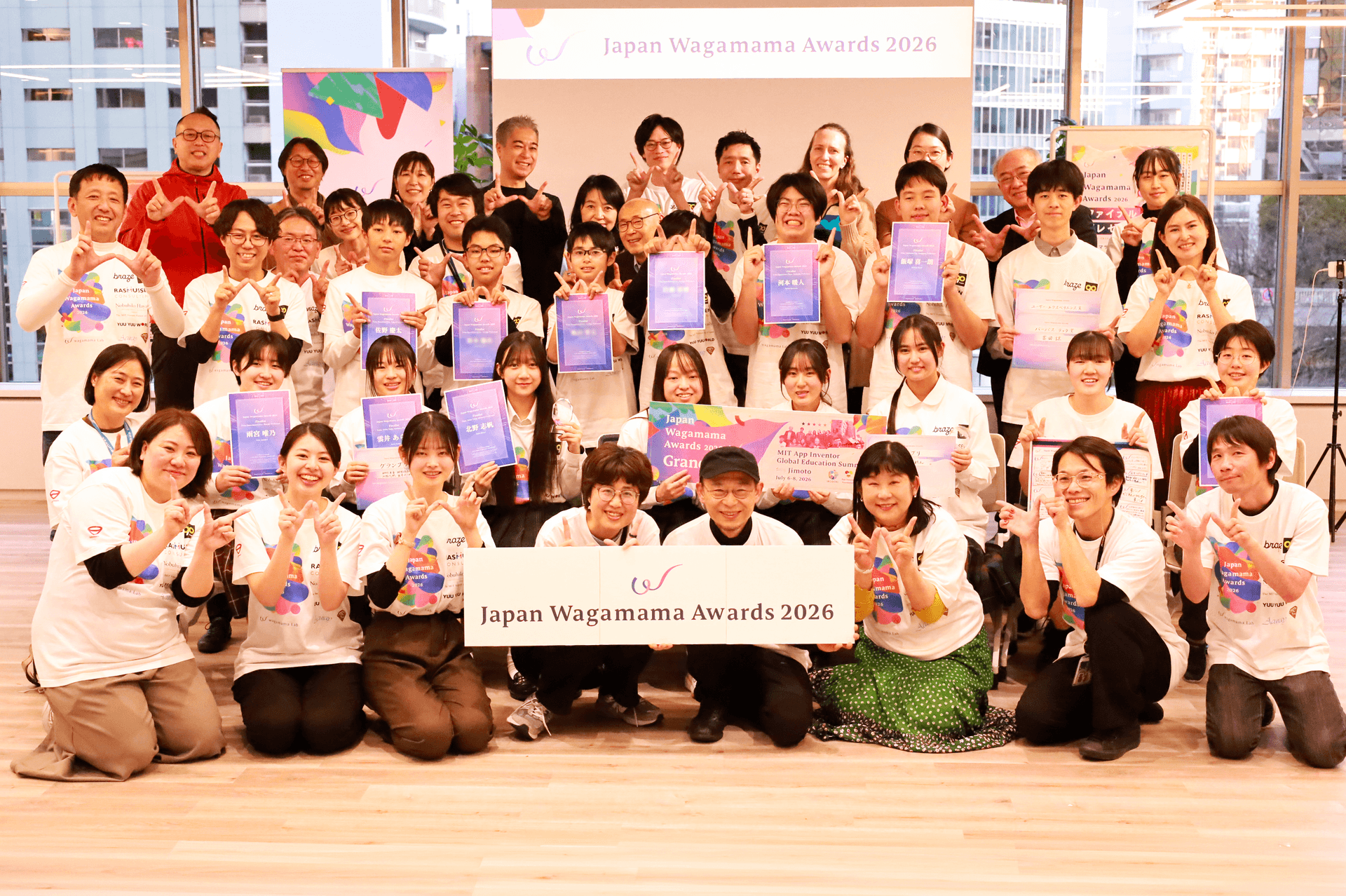 笑顔の大人数のグループが、2026年日本わがままアワードの表彰式で賞を手にポーズをとっている。