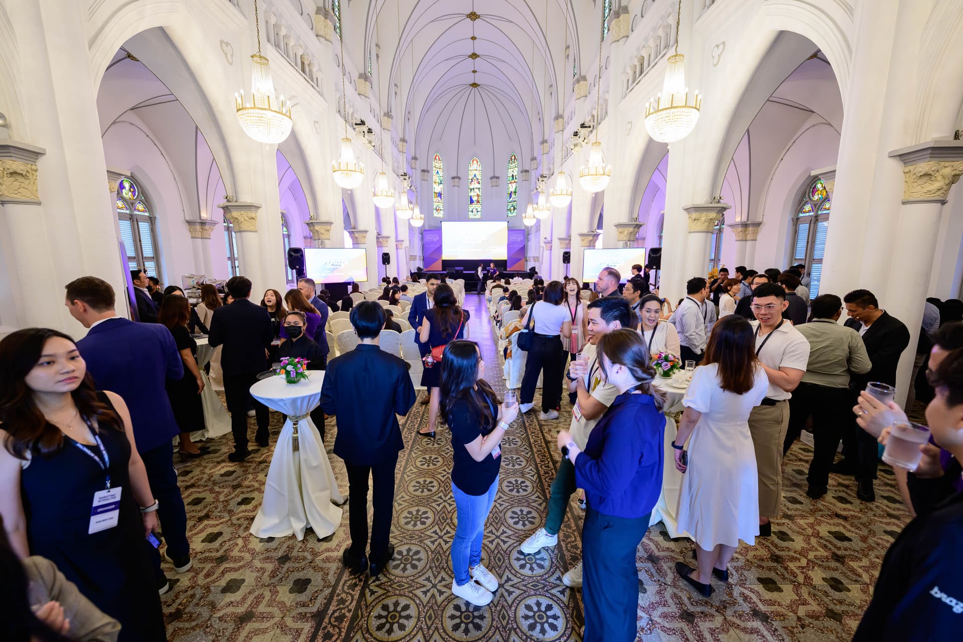 a large group of people are standing in a large room .