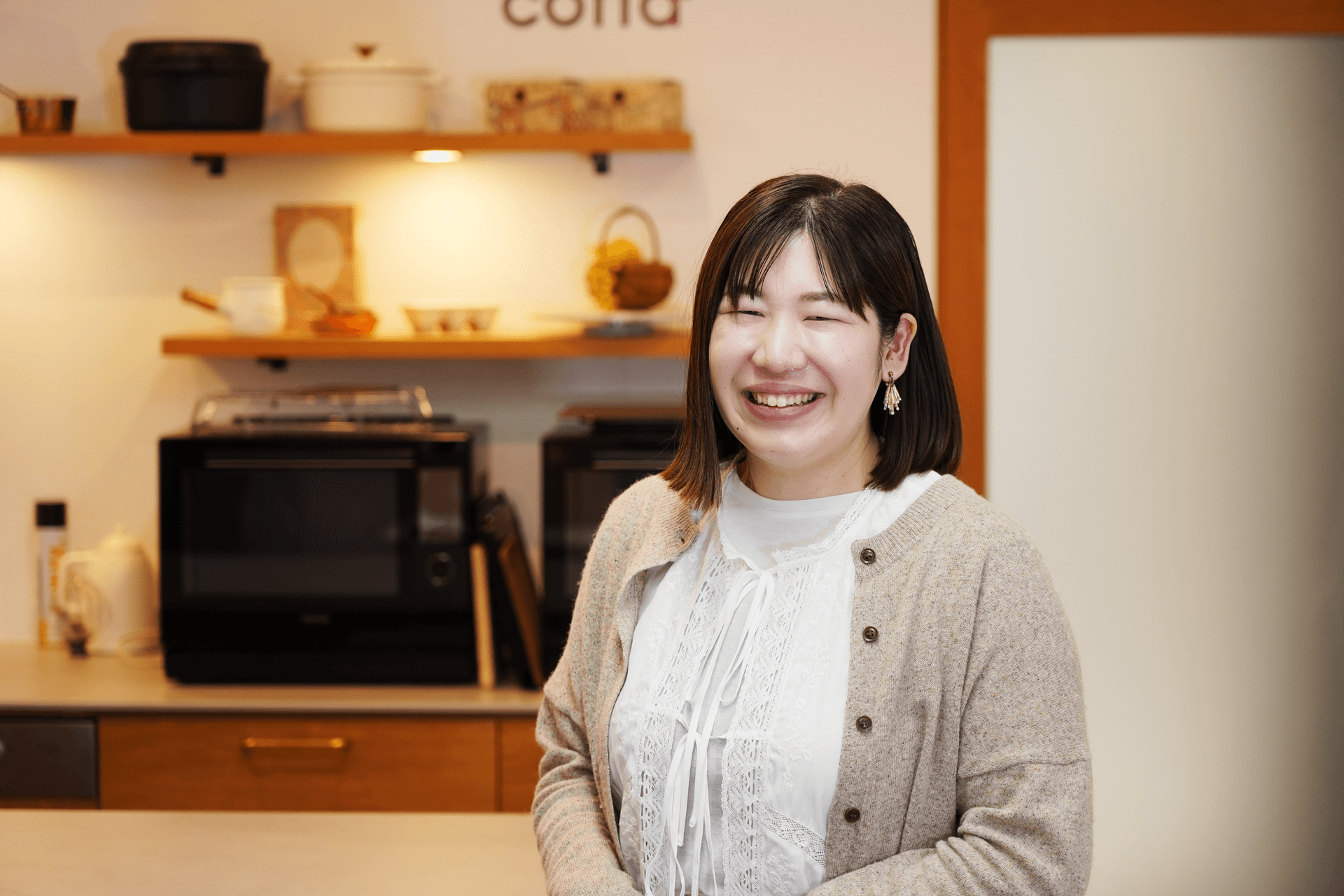a woman smiles in front of a sign that says cucina