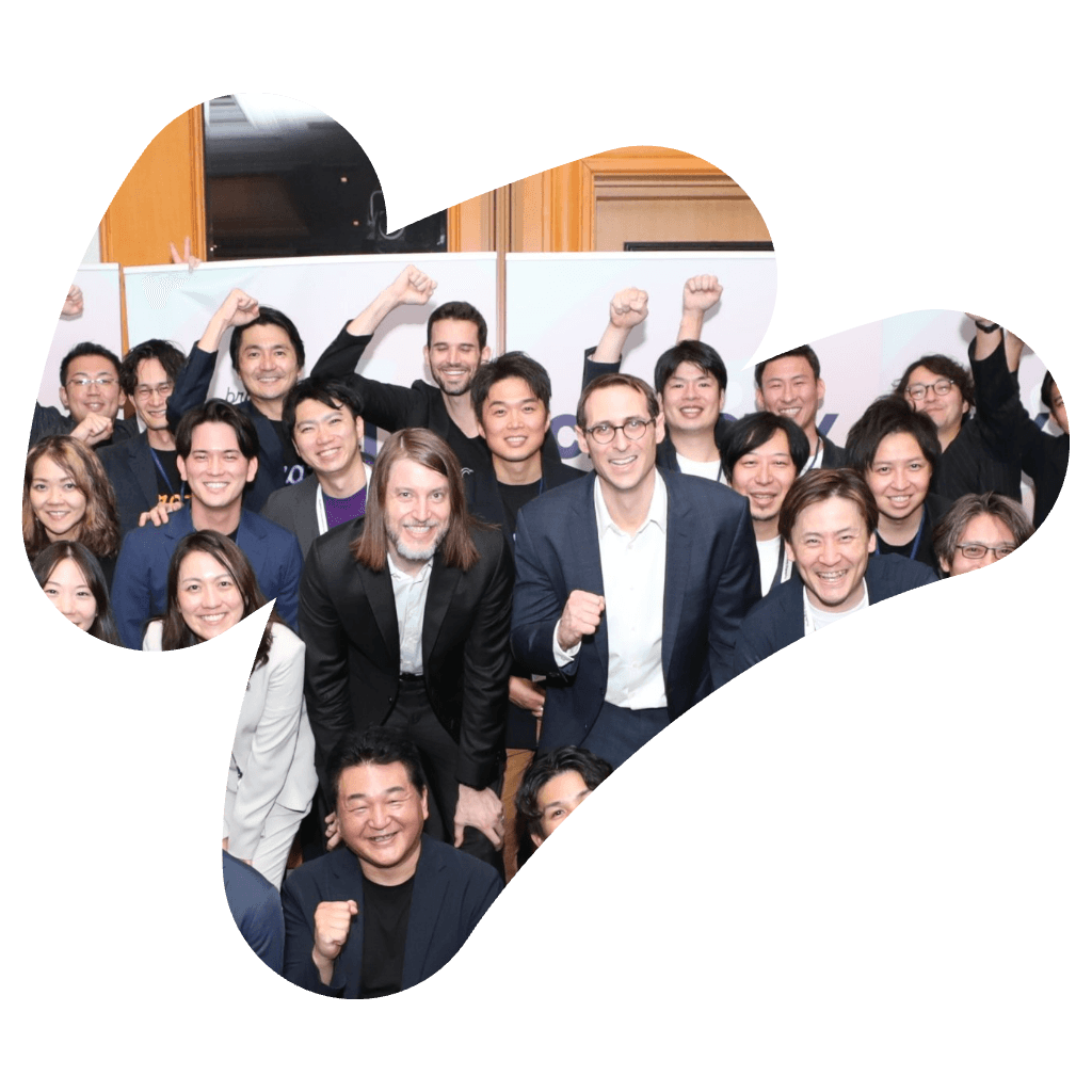 笑顔の多様な人々の集団。多くが拳を上げて、祝賀や成功のジェスチャーをしている。