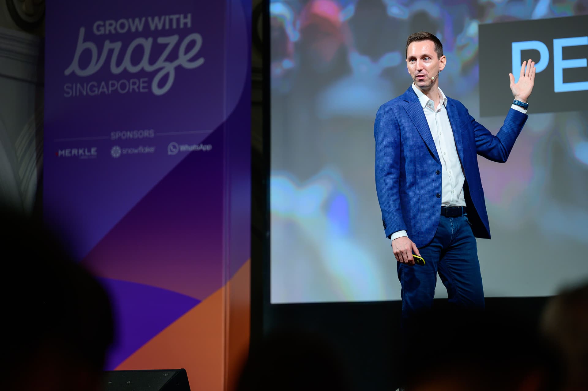 a man in a suit is standing on a stage giving a speech .