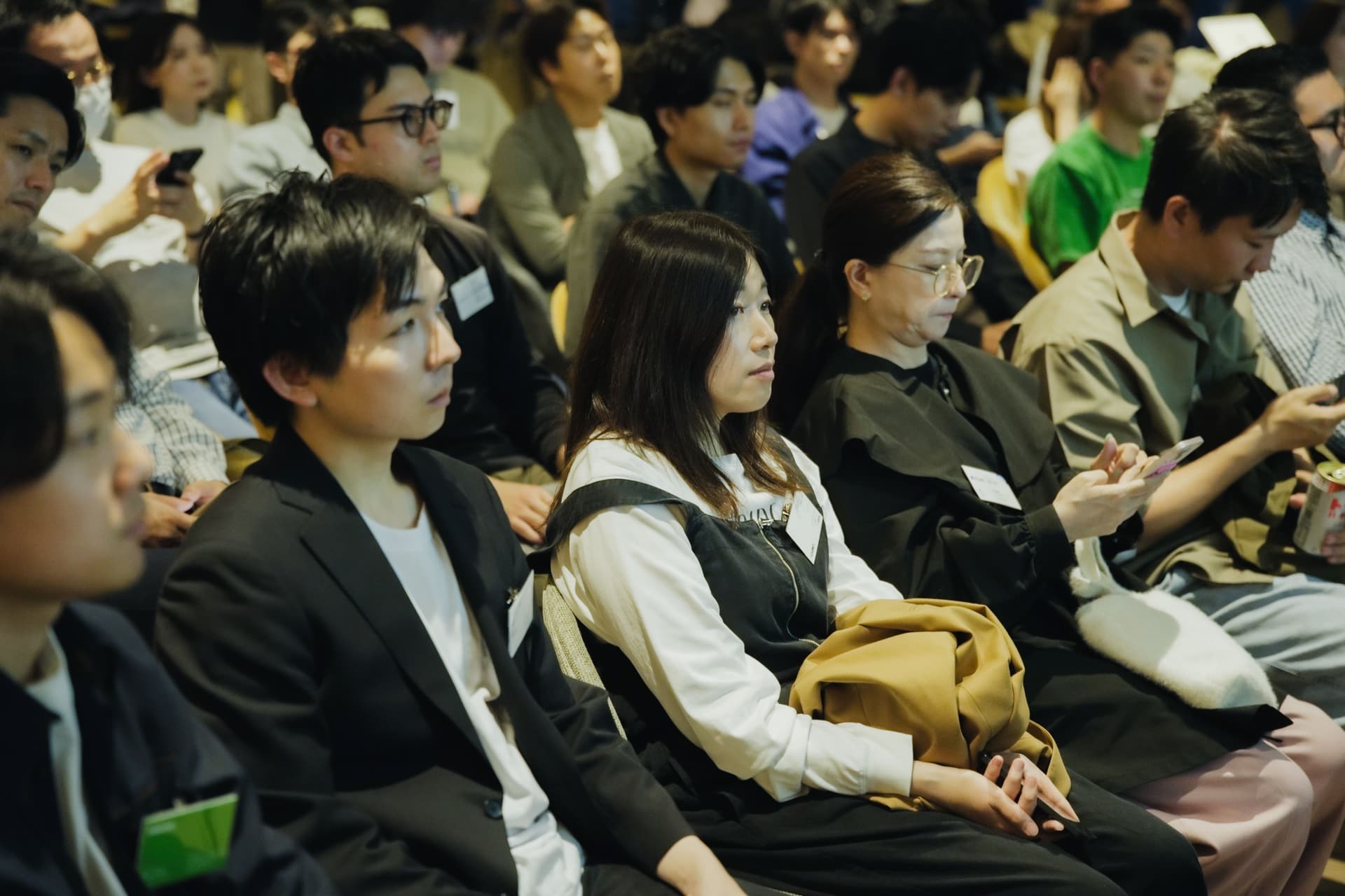 a group of people are sitting in a room watching a presentation .