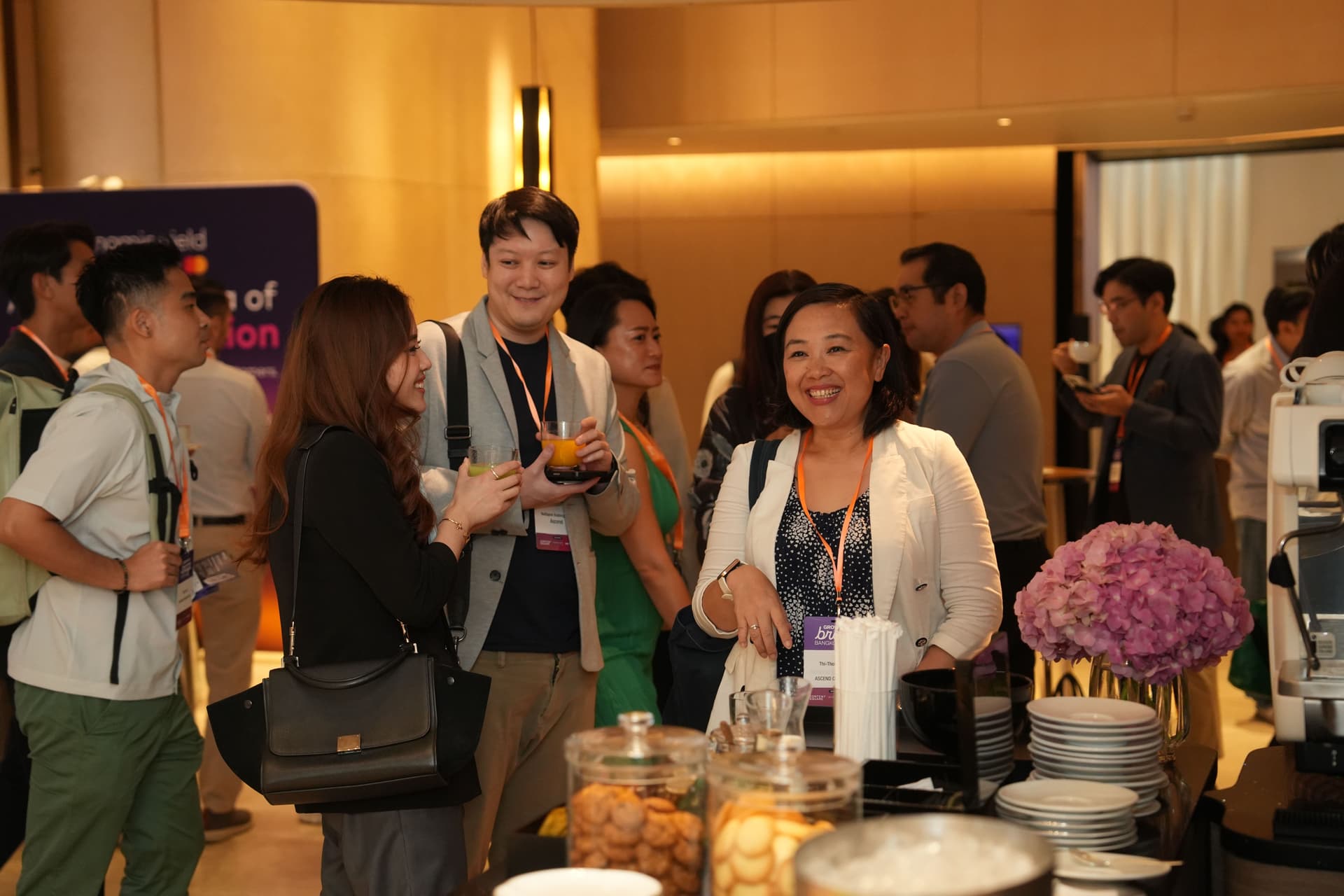 a group of people are standing around a table in a room talking to each other .