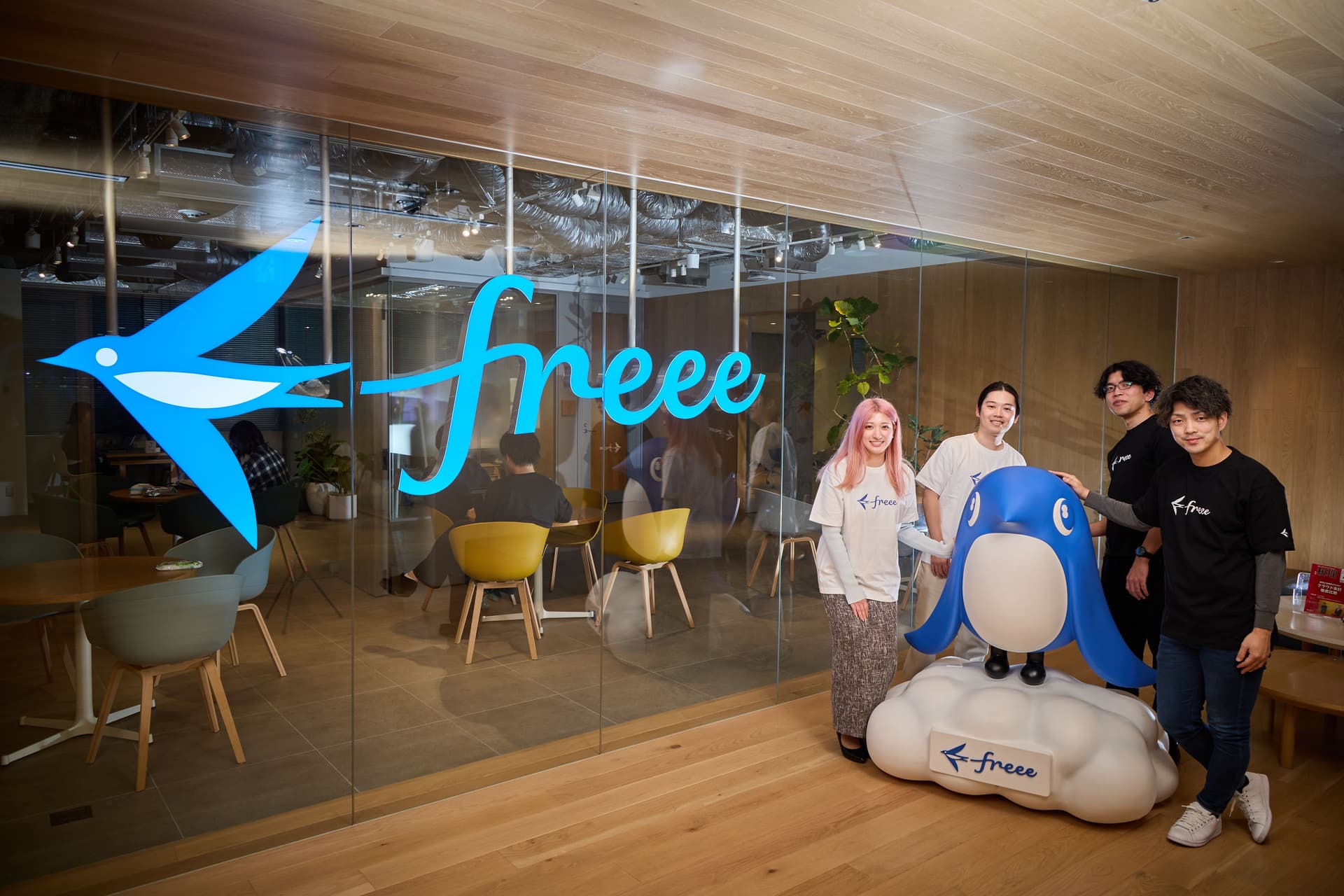 freeeのキャラクターとインタビューに答えた四人の社員が写っている