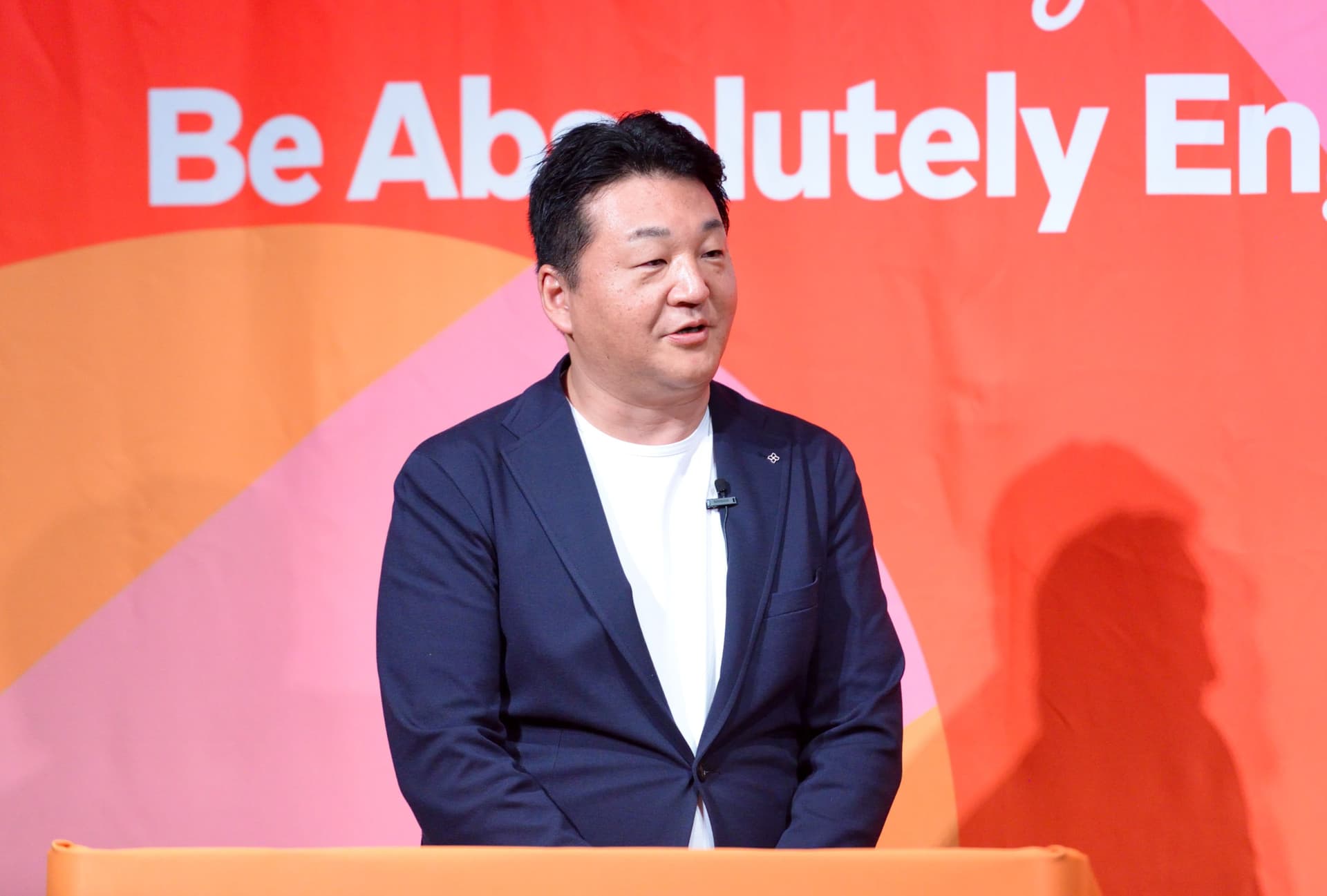 a man in a suit is standing at a podium giving a speech .