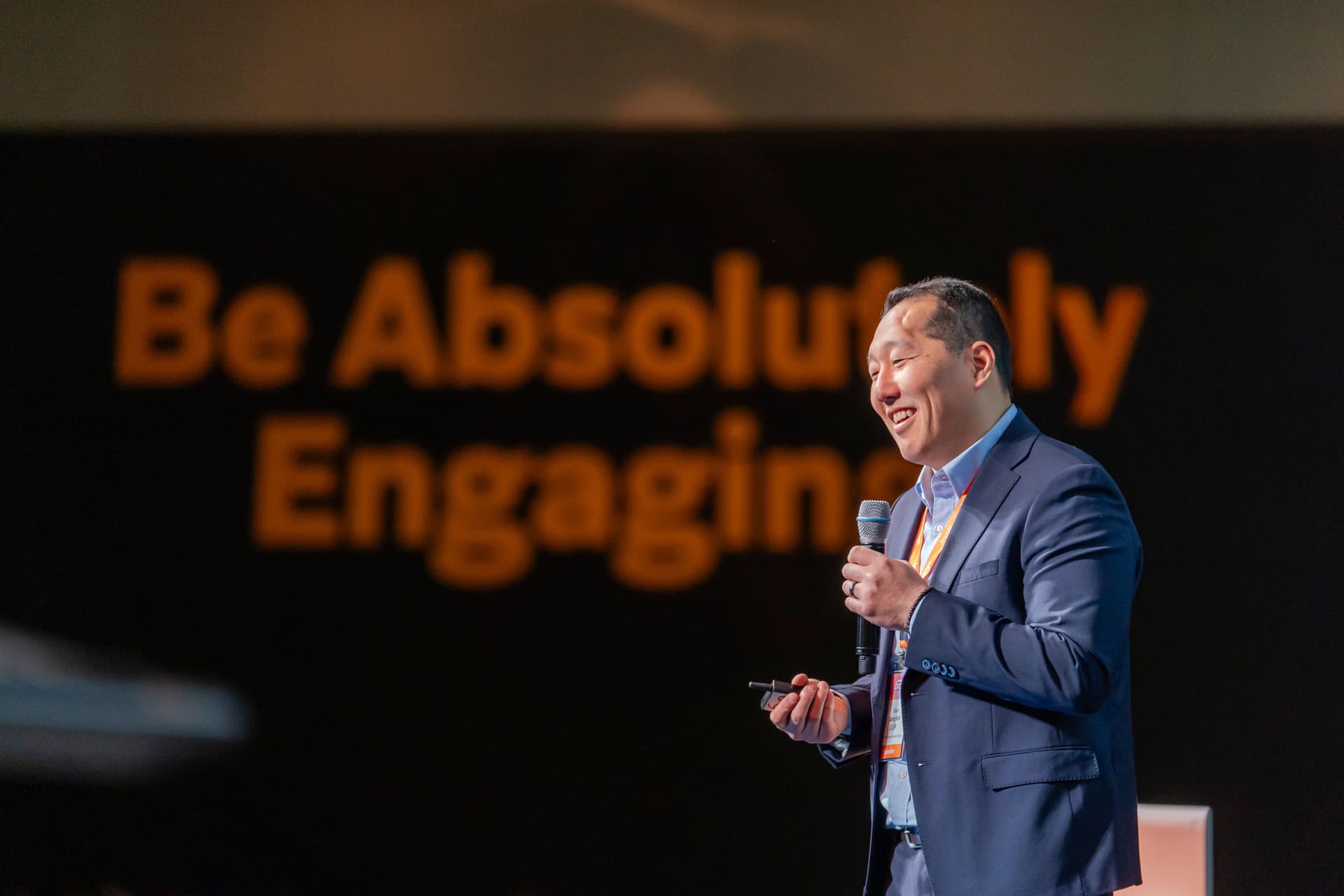 a man in a suit is holding a microphone and giving a speech .