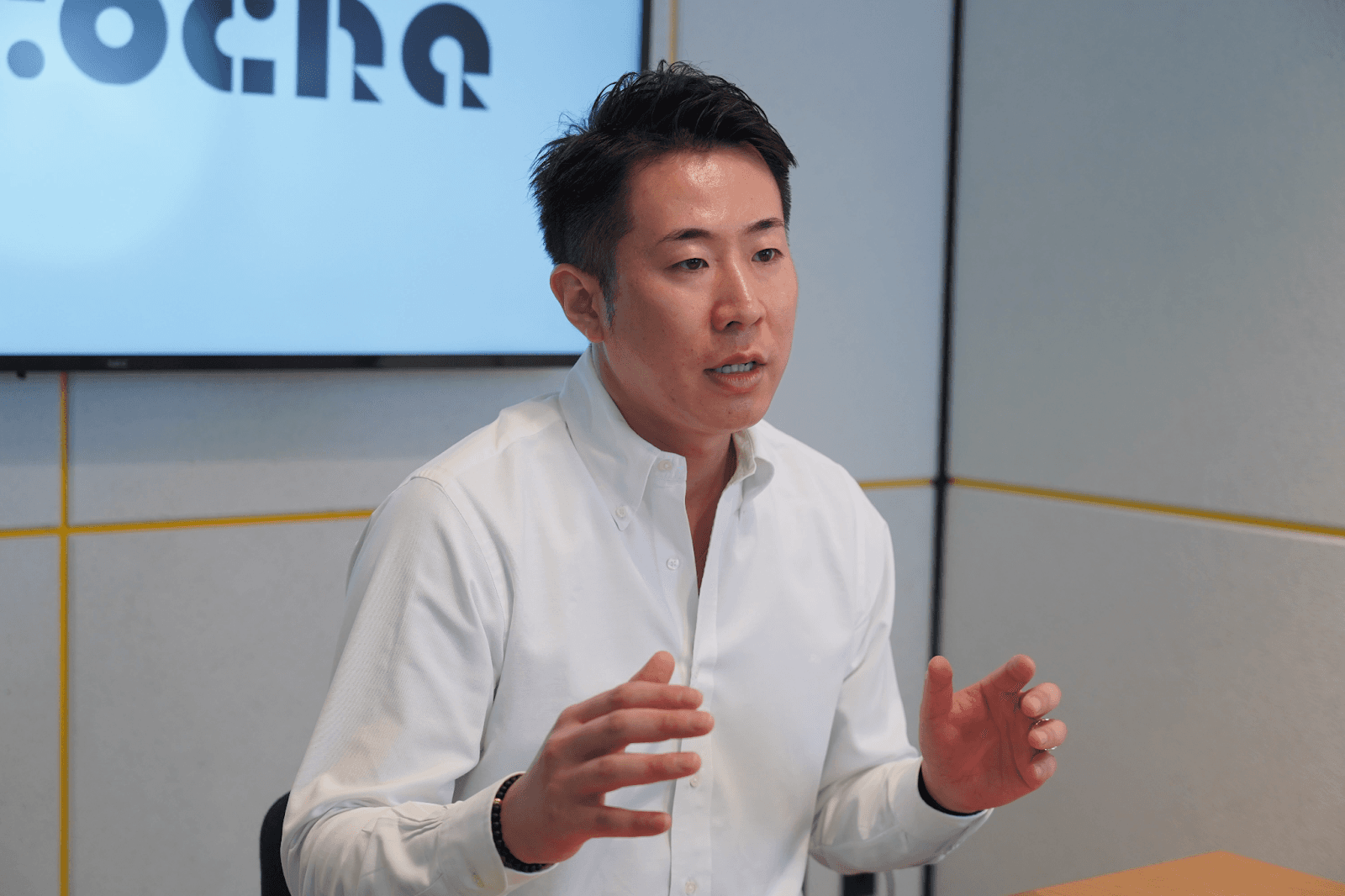 a man talking in front of a screen that says ocho