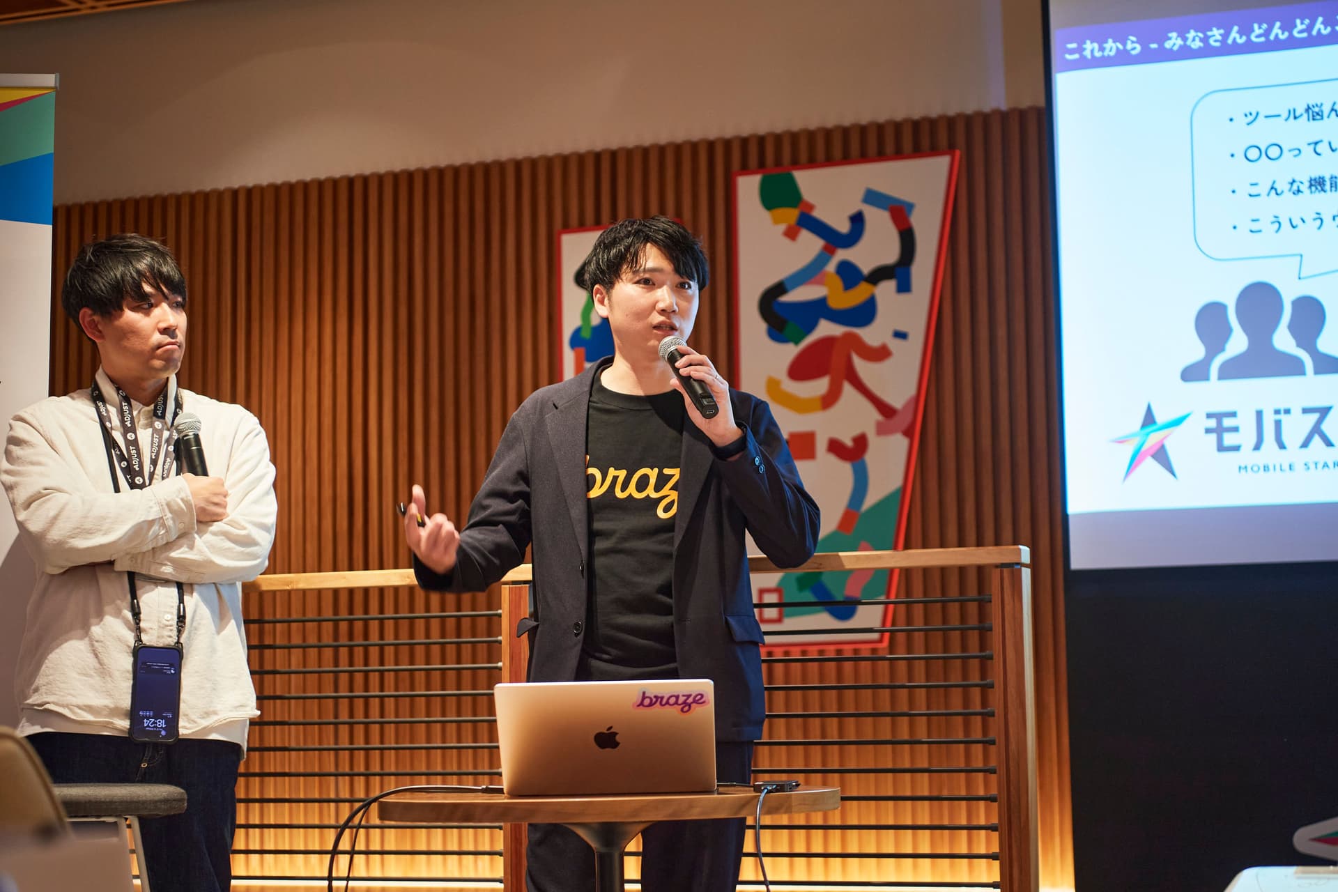 a man is standing in front of a laptop and a microphone .