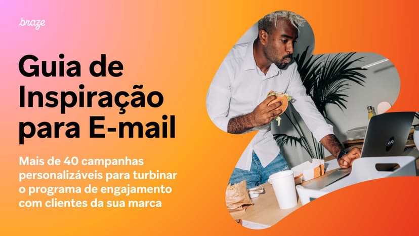 a man is sitting at a desk with a laptop and eating a sandwich .