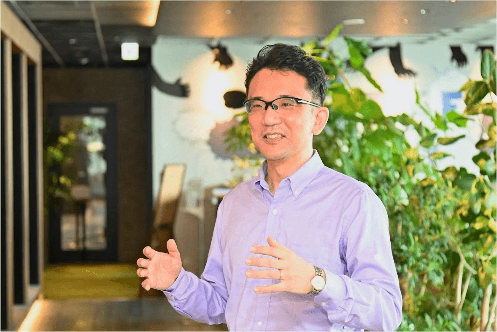 a man wearing glasses and a purple shirt is talking