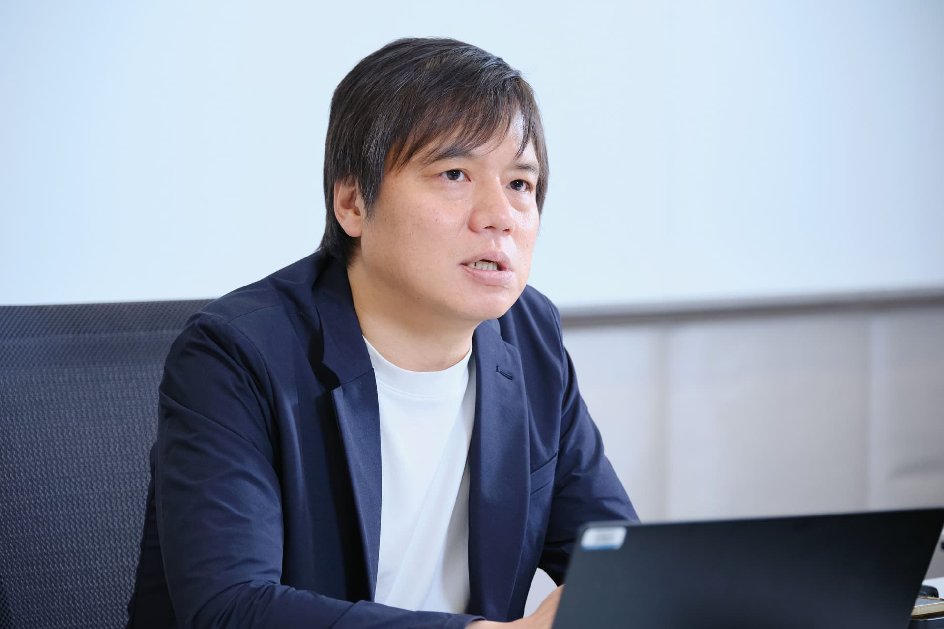 a man in a suit is sitting in front of a laptop computer .
