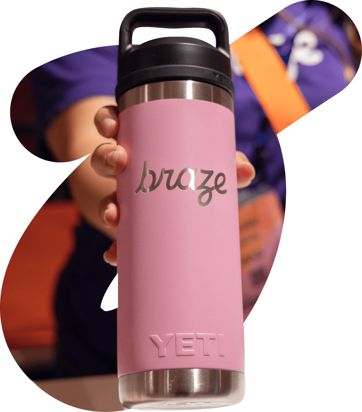 A hand holds a pink YETI water bottle customized with the "braze" logo.