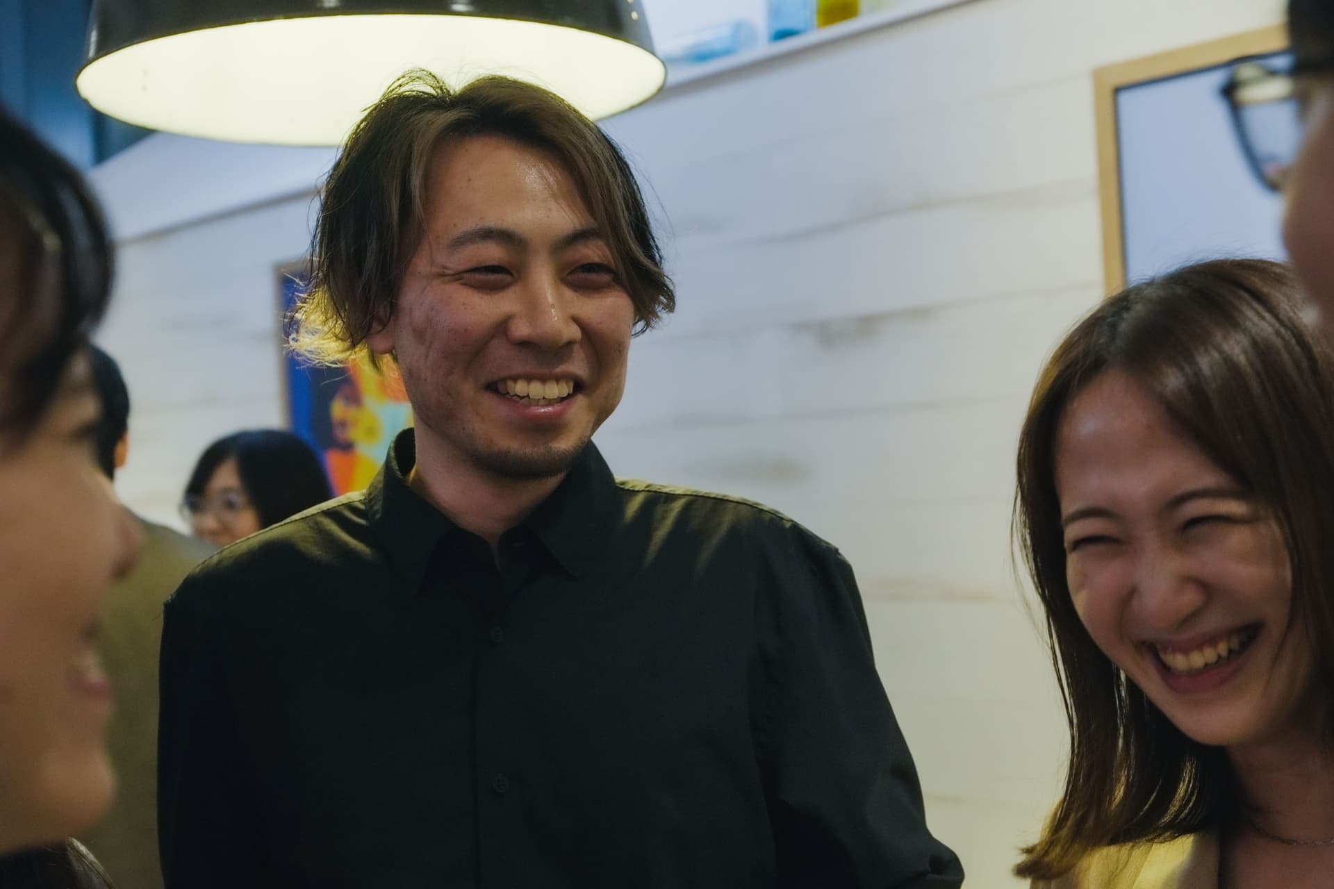 a group of people are standing next to each other and smiling .