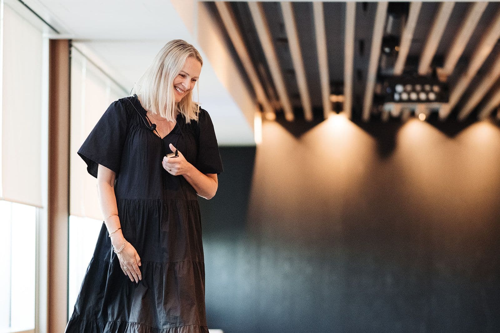 a woman in a black dress is standing in a room .
