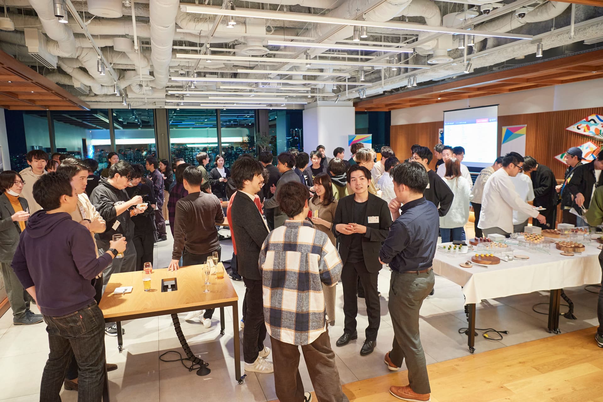 a large group of people are standing around a table at a party .
