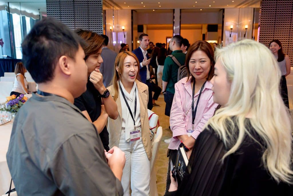 Attendees smiling and chatting at a professional networking event.