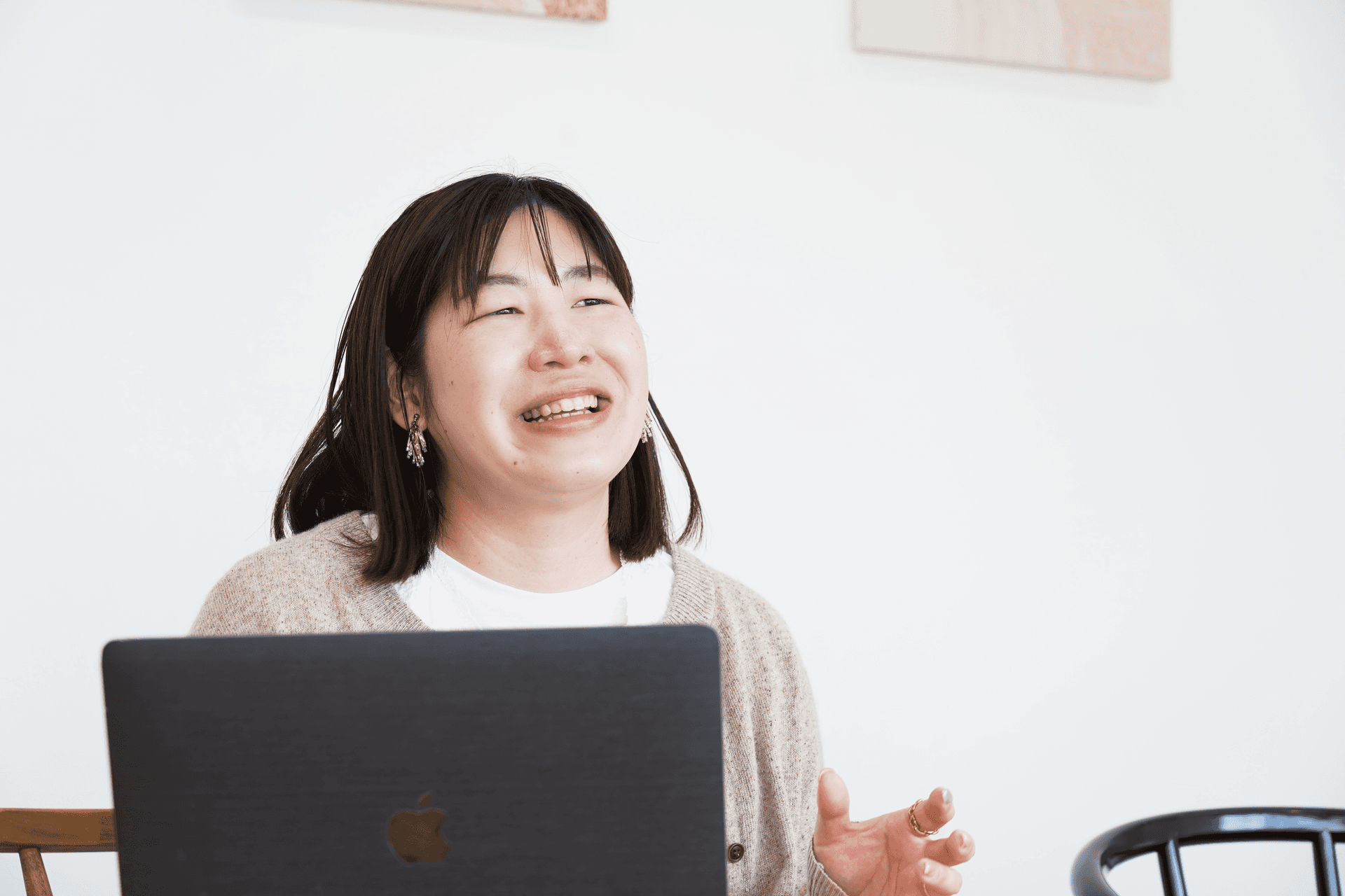 a woman is sitting in front of an apple laptop