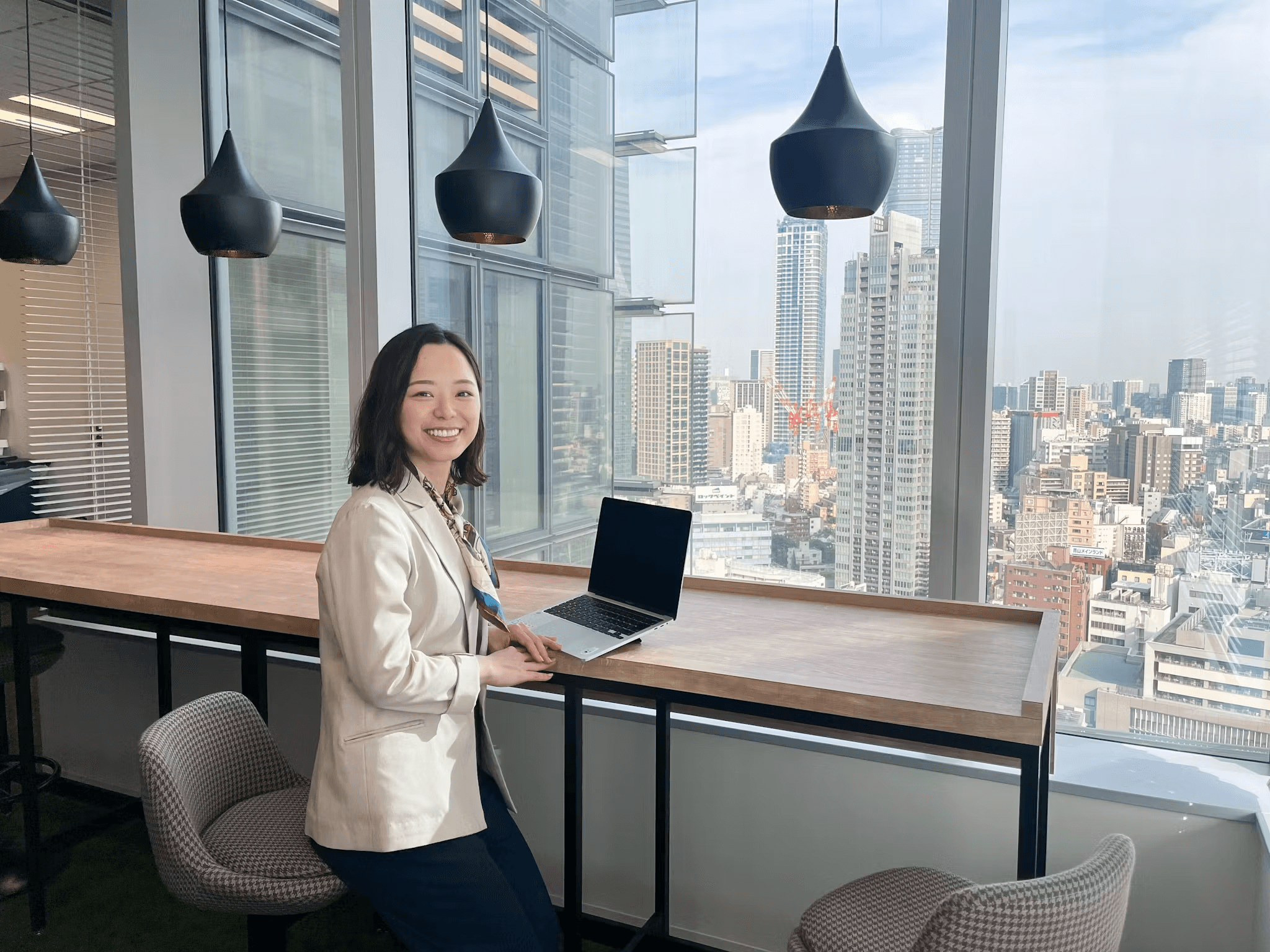 a woman sitting at a table with a laptop on it