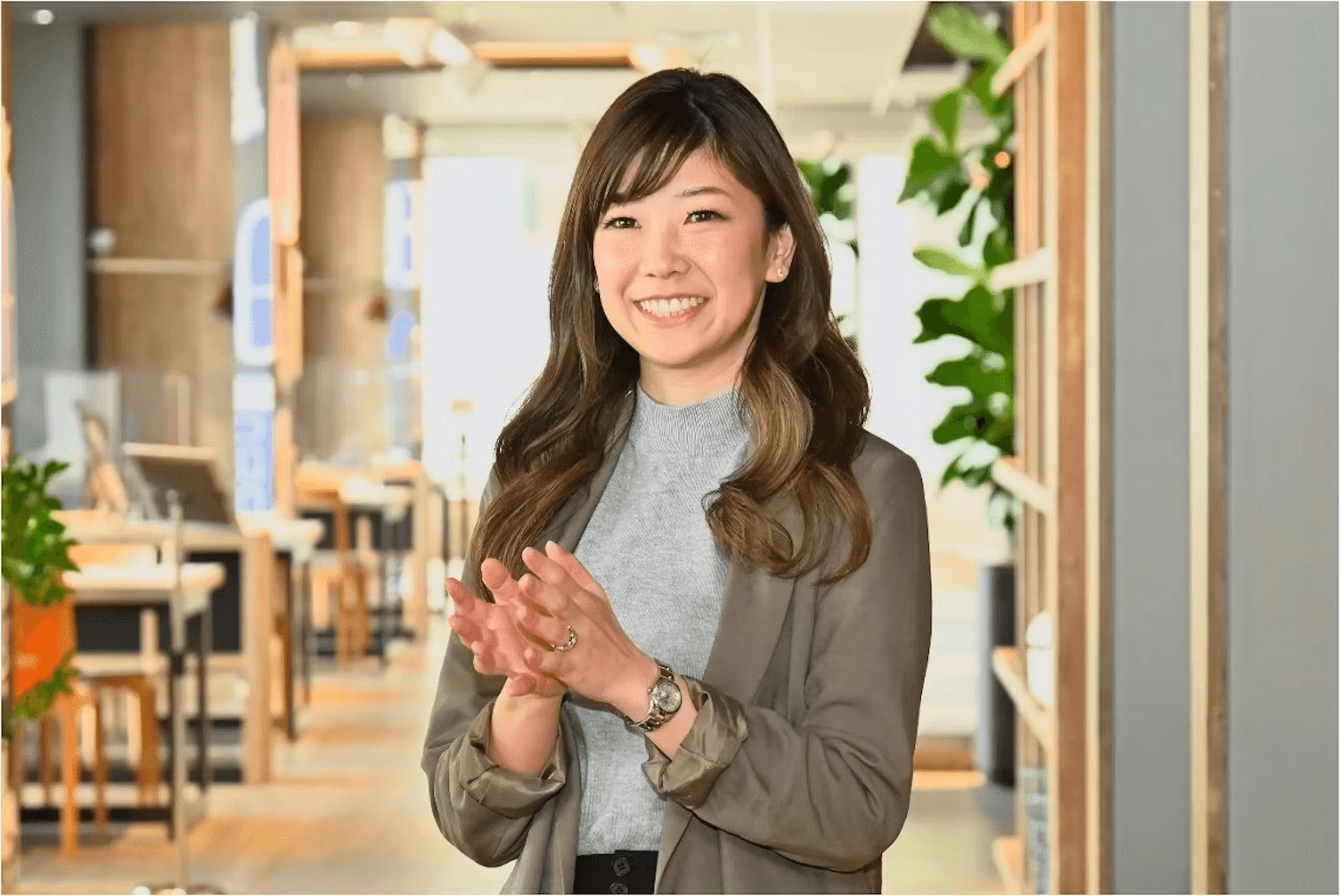 a woman wearing a watch applauds in an office