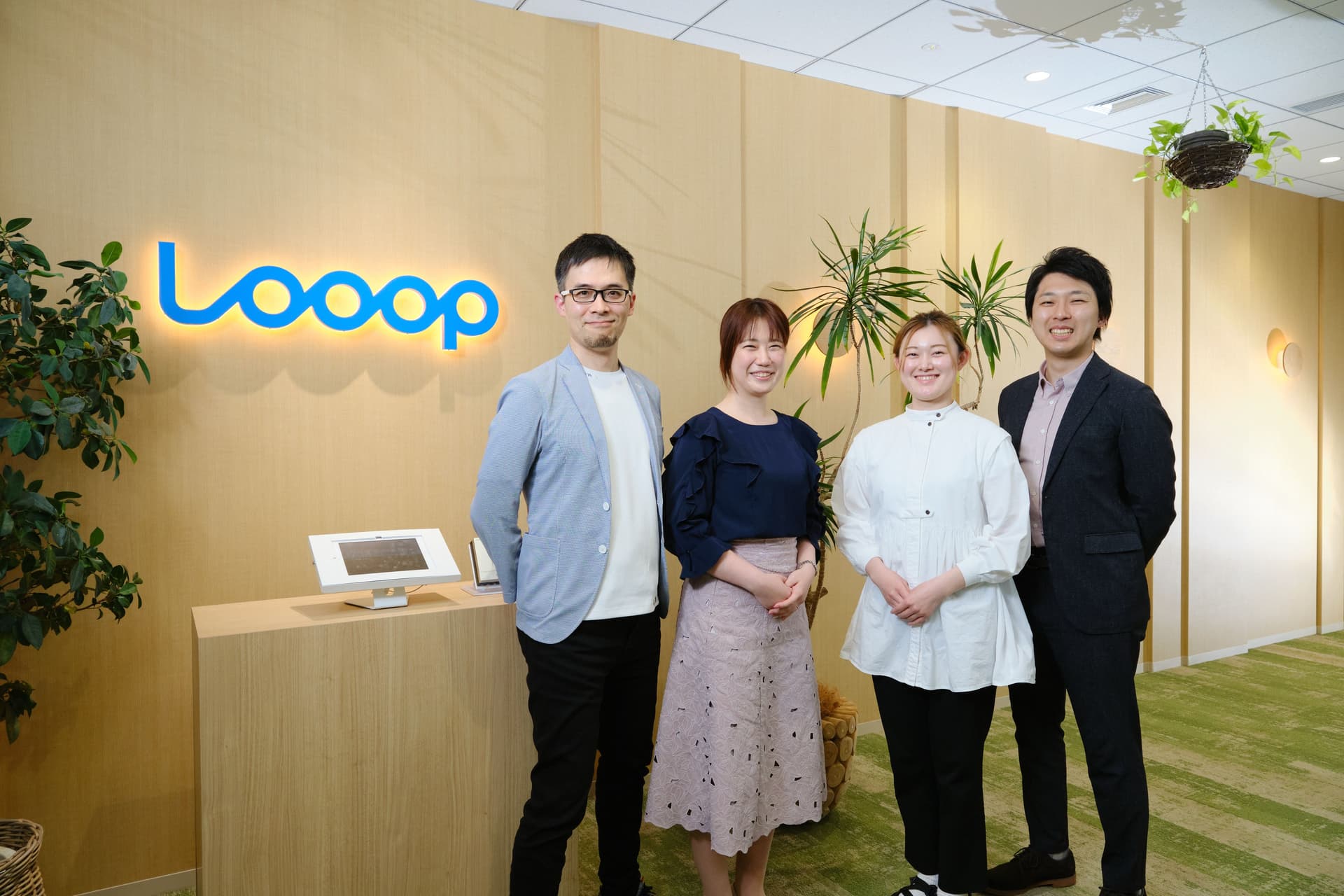 a group of people are standing in front of a sign that says loop .