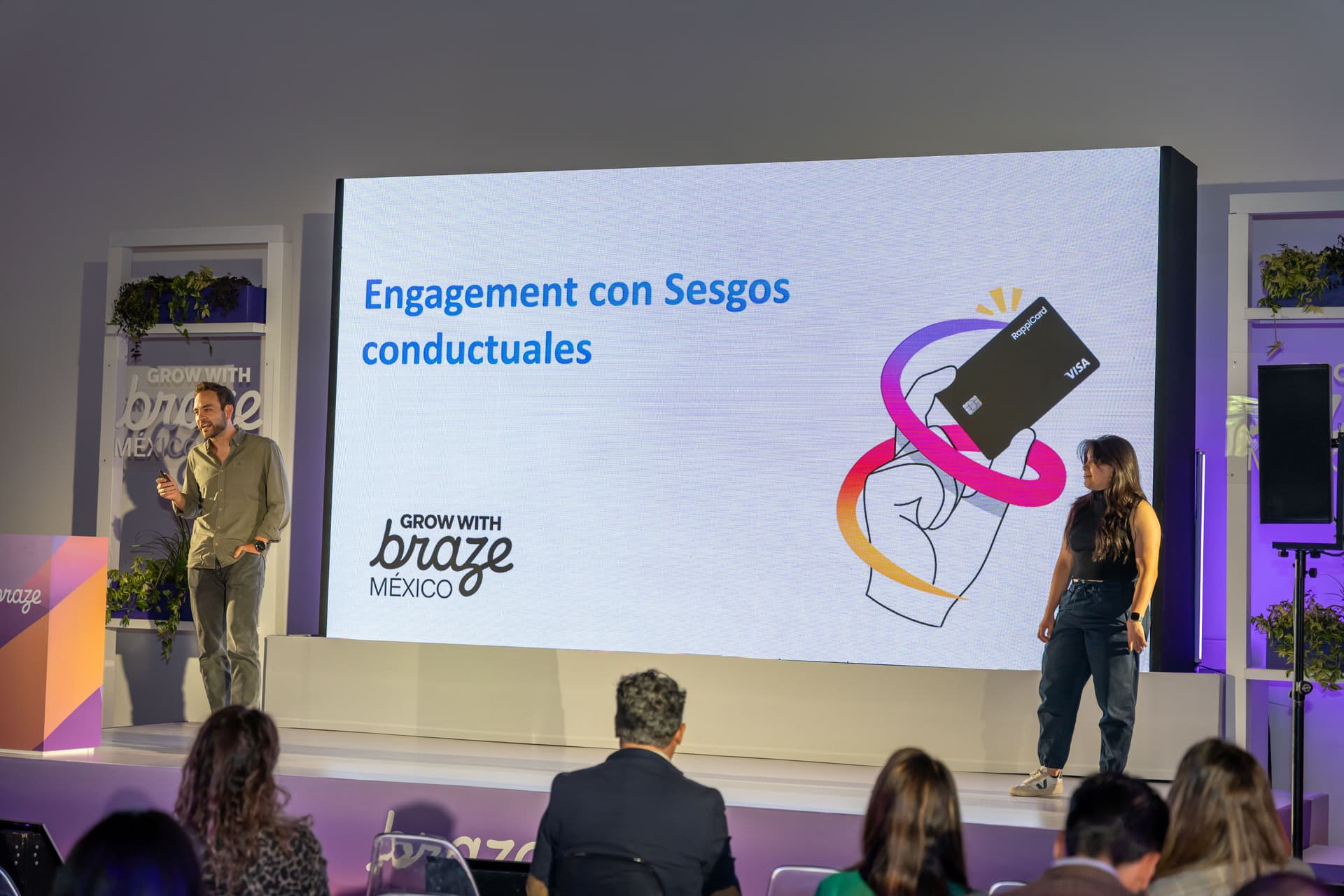 Uma imagem de duas pessoas em frente a uma tela grande mostrando o Rappicard