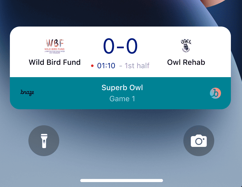 Eine Live-Aktivität auf dem Sperrbildschirm eines iPhones mit den Spielständen von zwei Mannschaften. Sowohl das Wild Bird Fund-Team als auch das Owl Rehab-Team haben eine Punktzahl von 0.